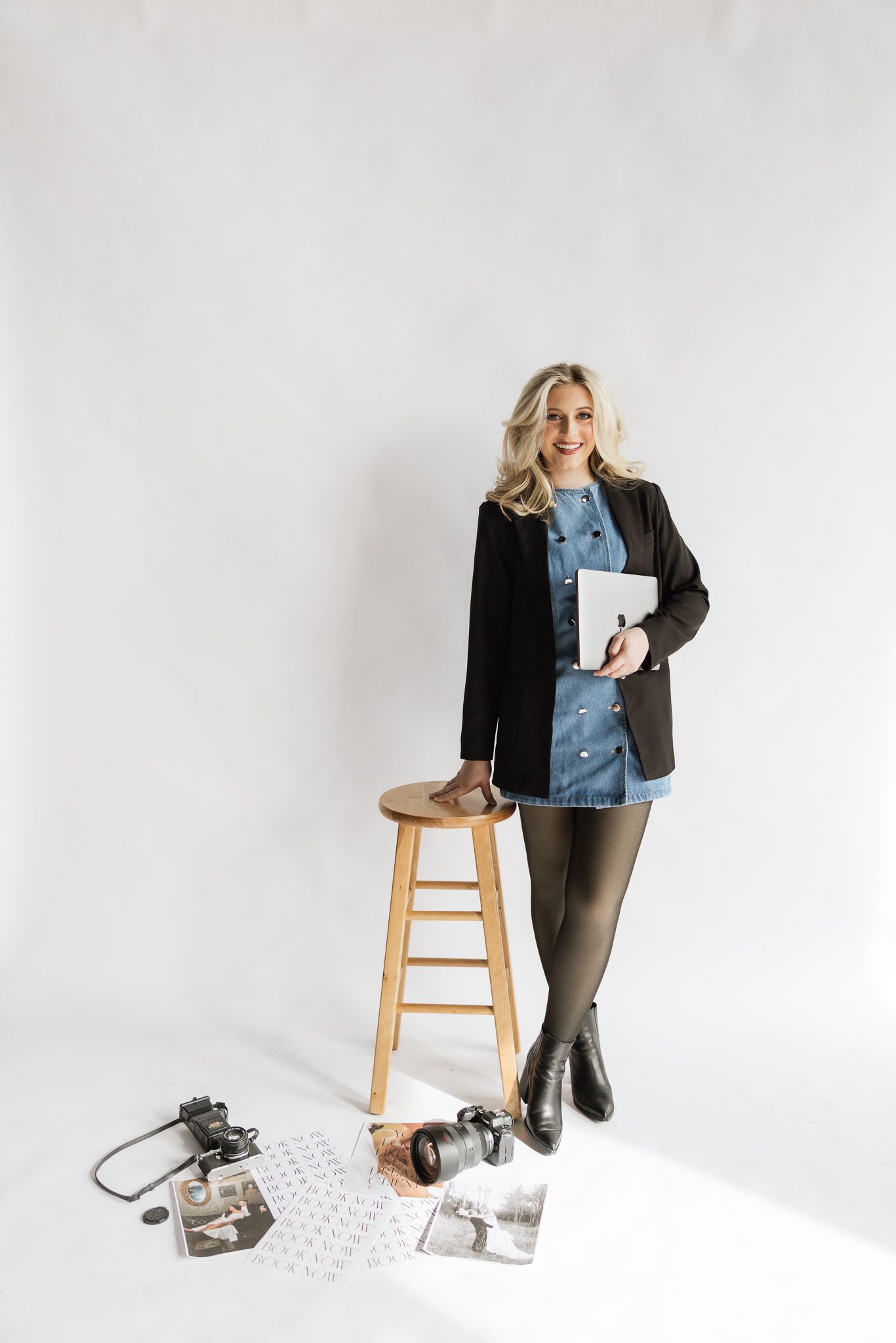 Studio photography session with wooden stool and camera equipment on white background.
