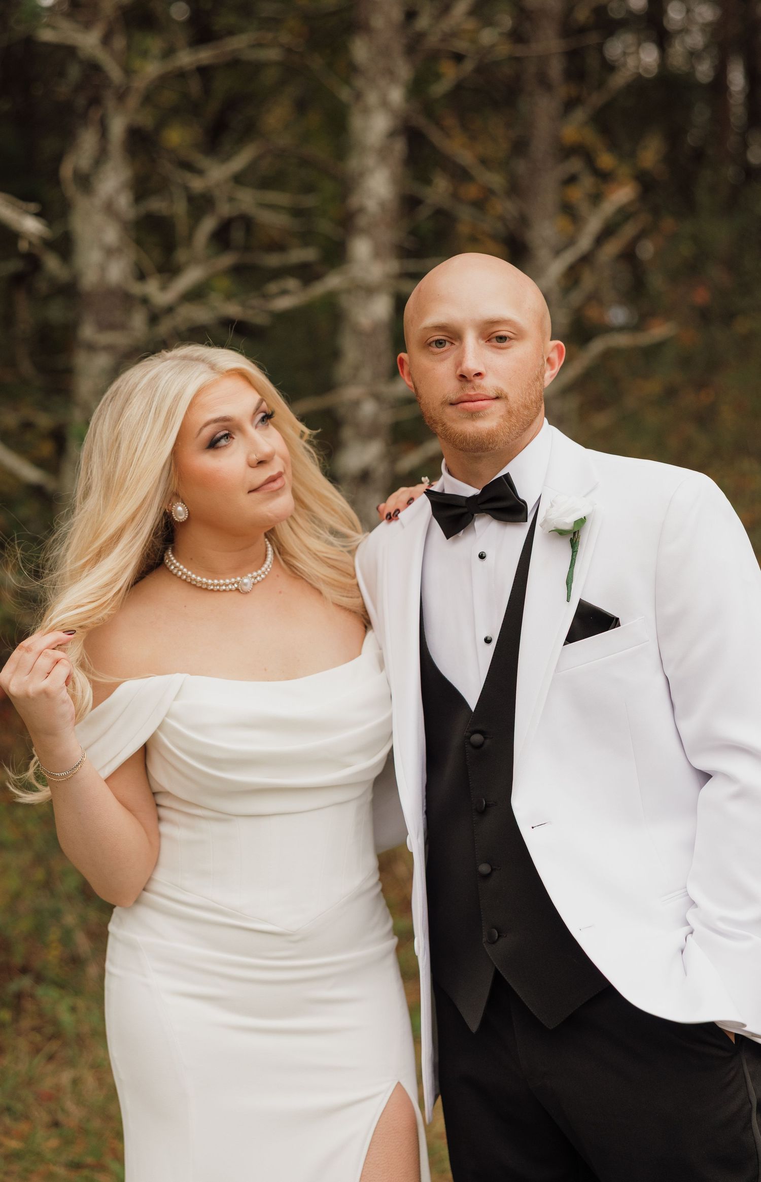 Wedding portrait featuring formal attire against a natural wooded background.