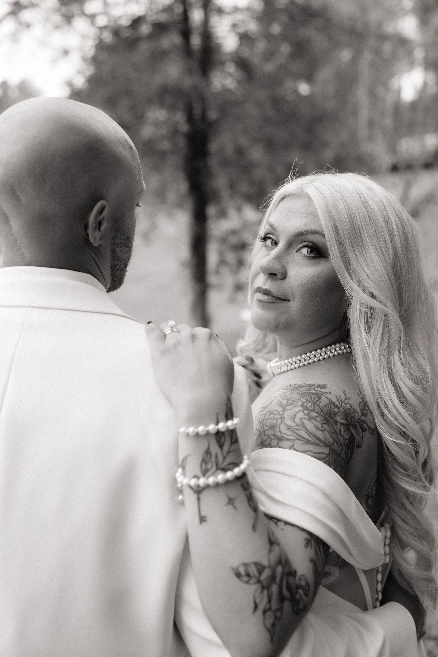 A black and white wedding photo collage showing romantic close-up moments between a couple outdoors.