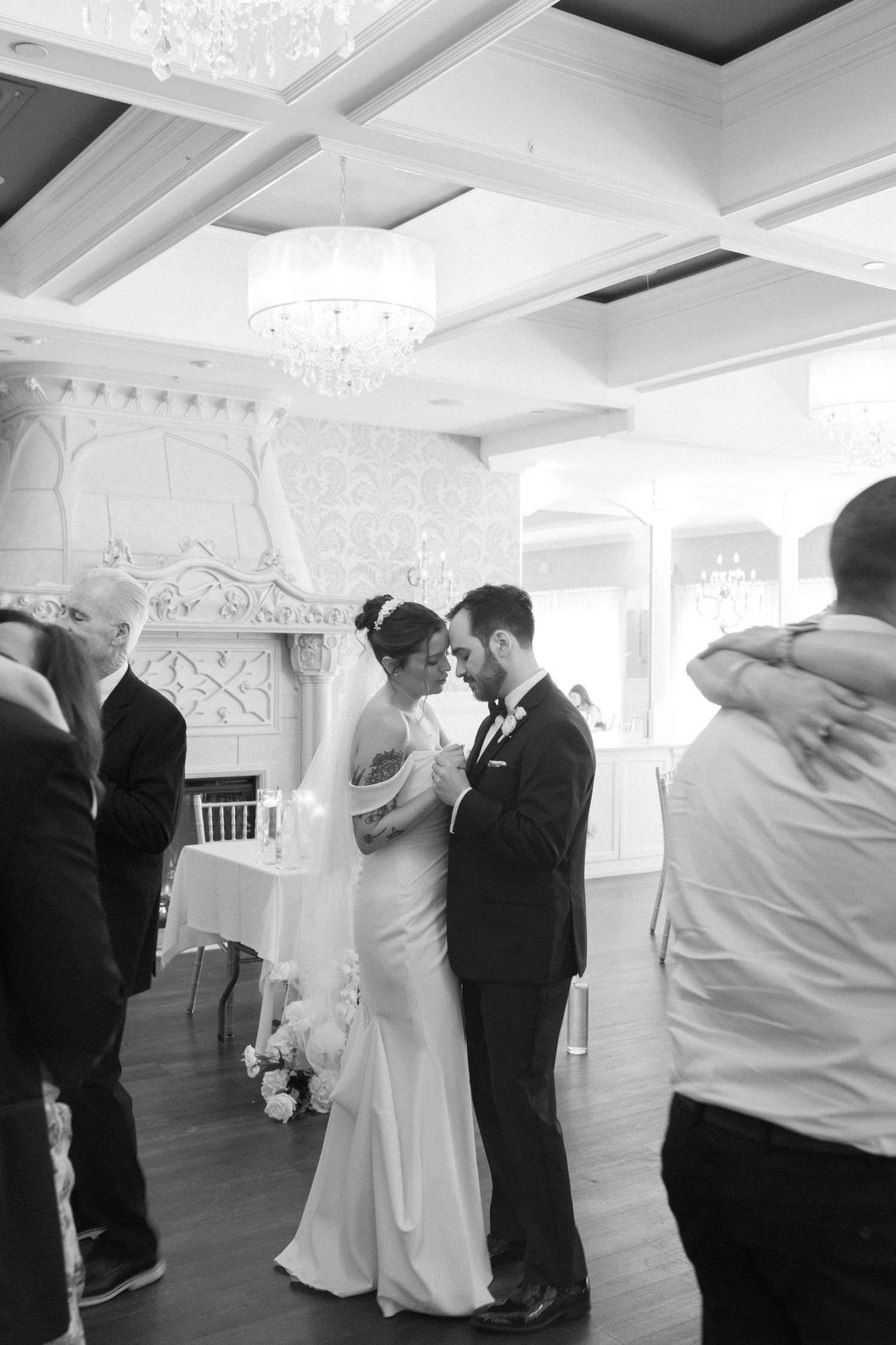 Black and white photo of bride and groom sharing quiet moment together during wedding ceremony.