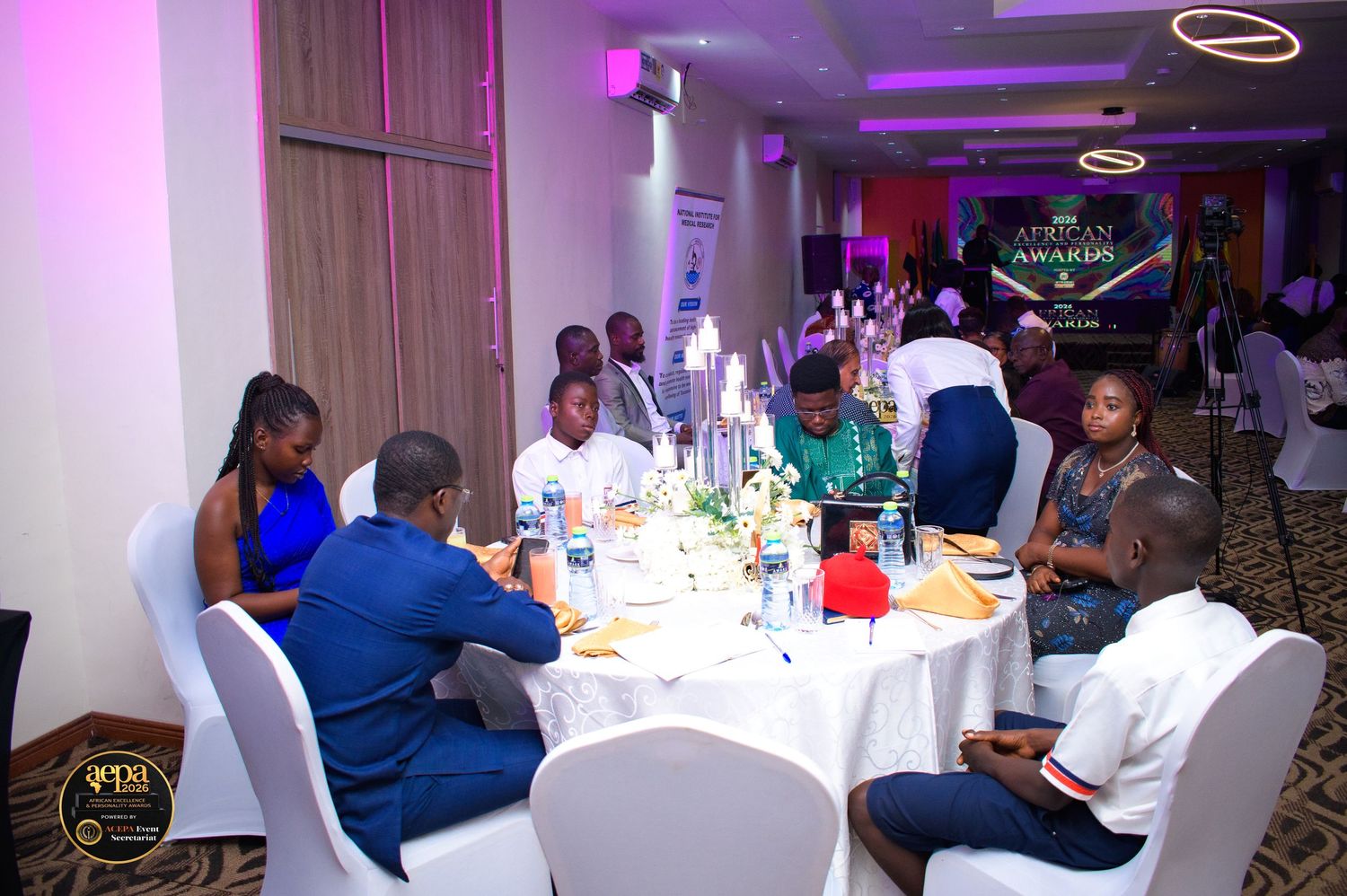 Guests seated at round tables during an African awards gala dinner in an elegant banquet hall.