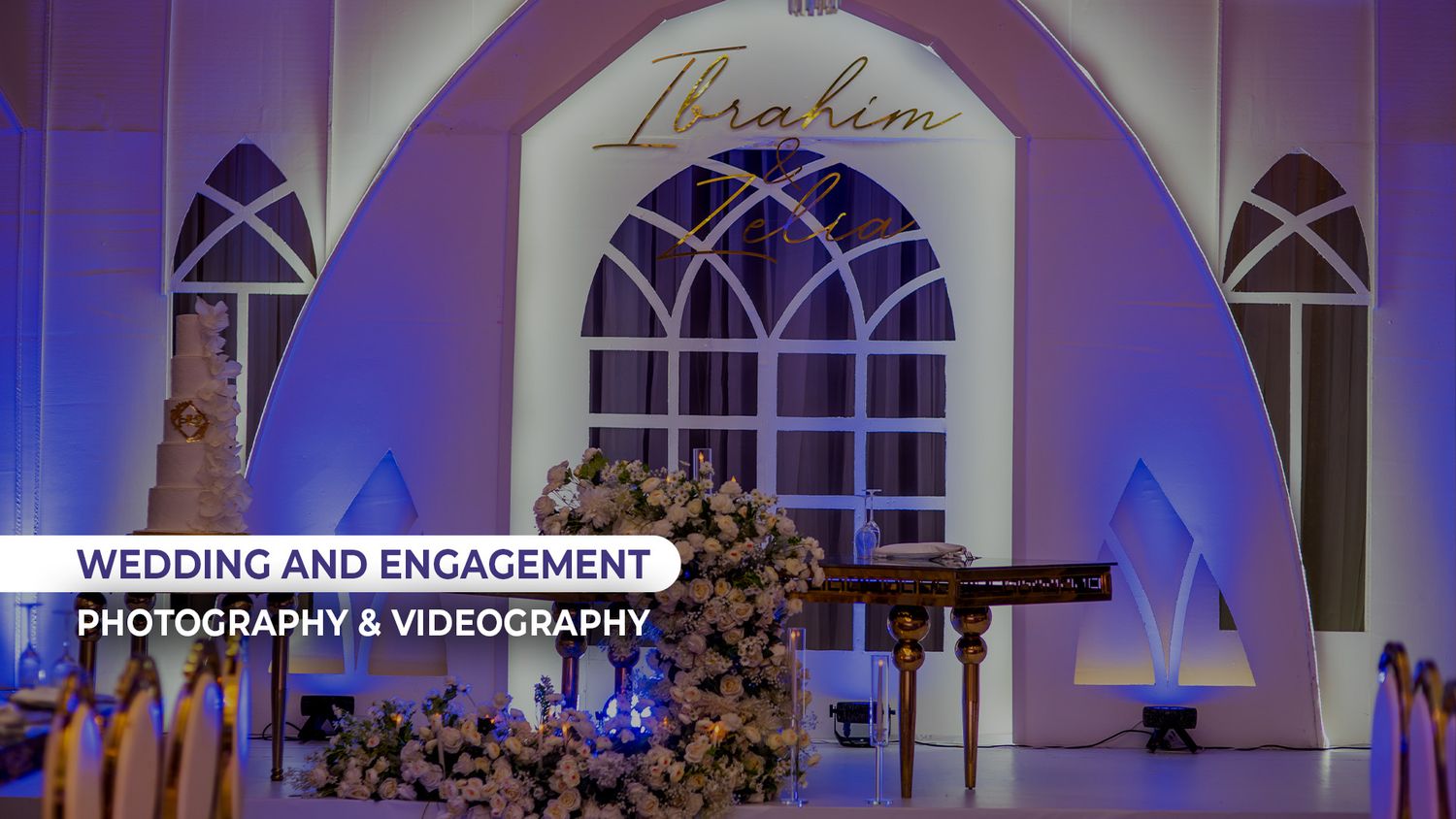 Elegant wedding venue decorated with white flowers and purple lighting displaying the name Ibrahim.