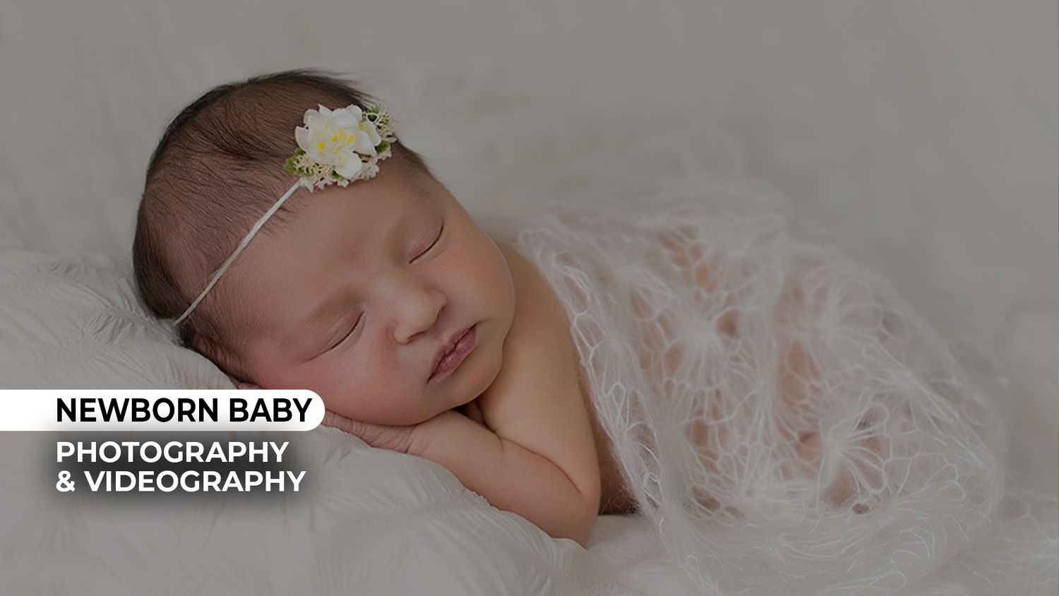Peaceful newborn baby sleeping wrapped in soft pink fabric with a delicate floral headband.
