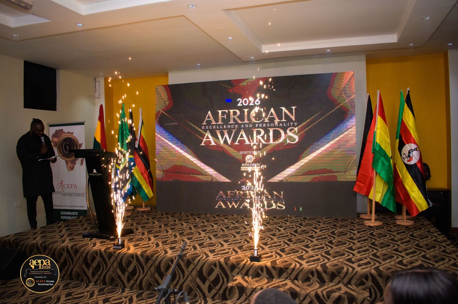 African Excellence Awards 2024 stage display with fireworks, flags of African nations, and decorative backdrop.
