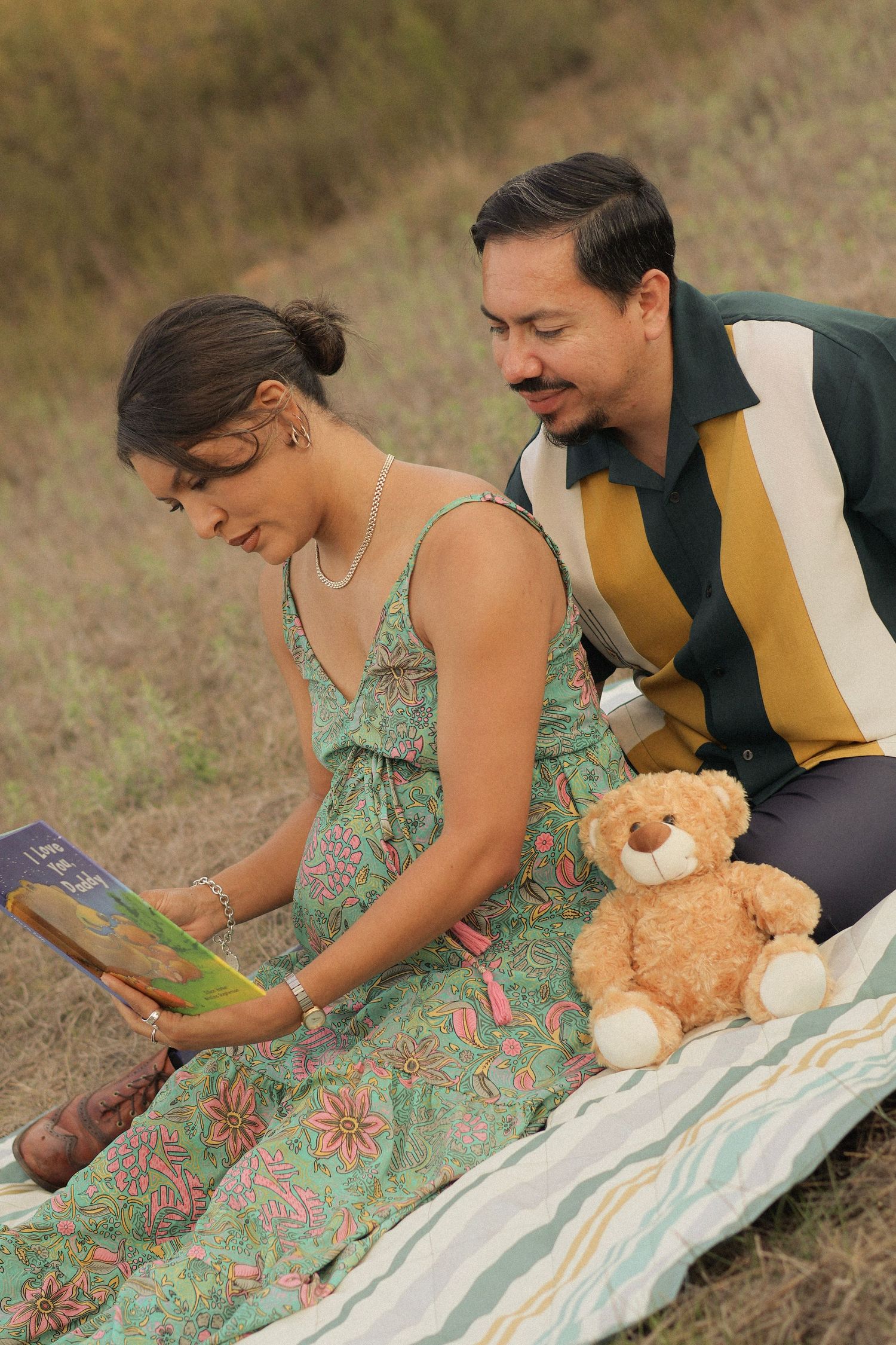 Couple reading a book together at sunset in Menifee field