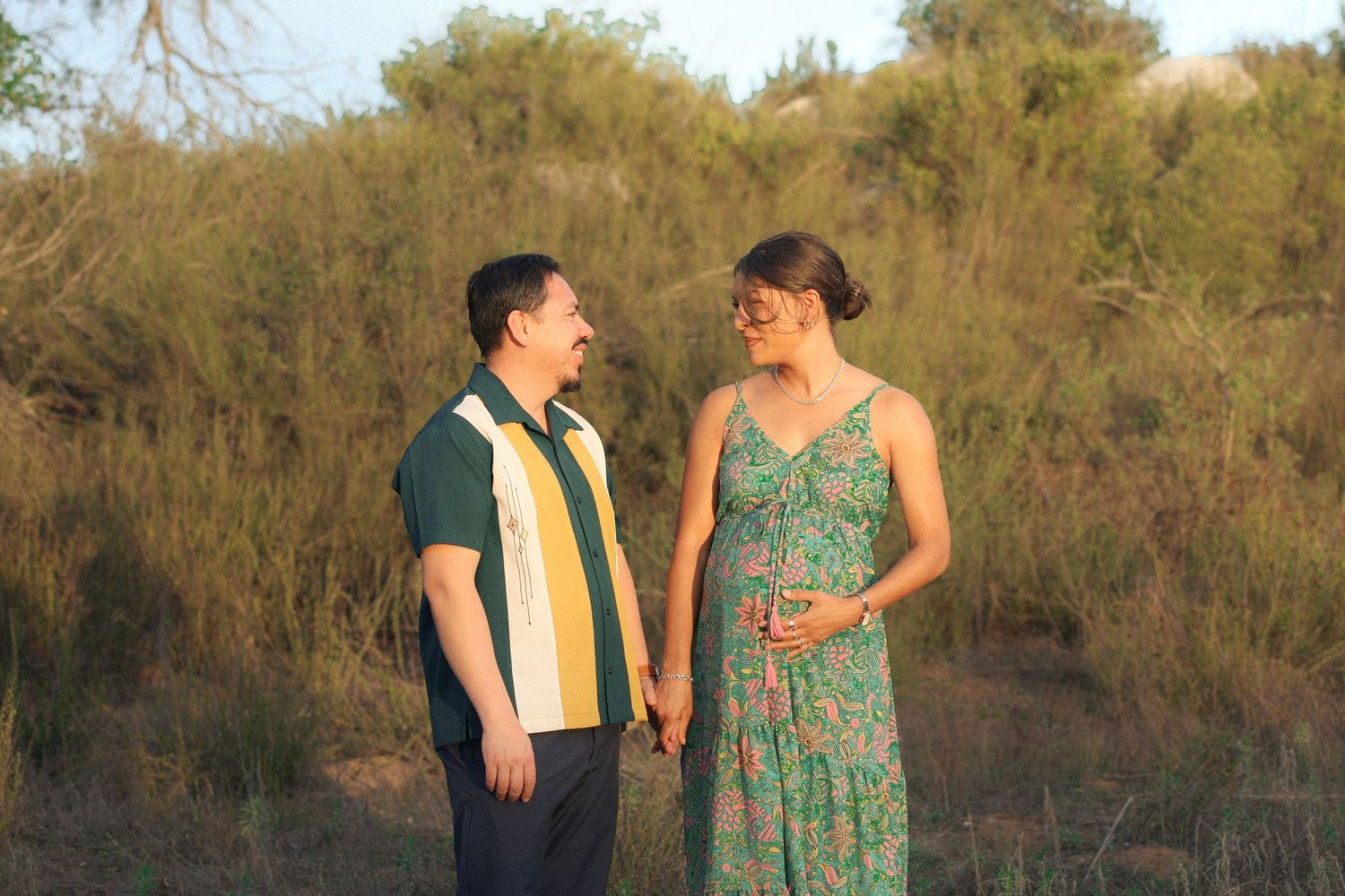 couple walking hand in hand romantically through Temecula field