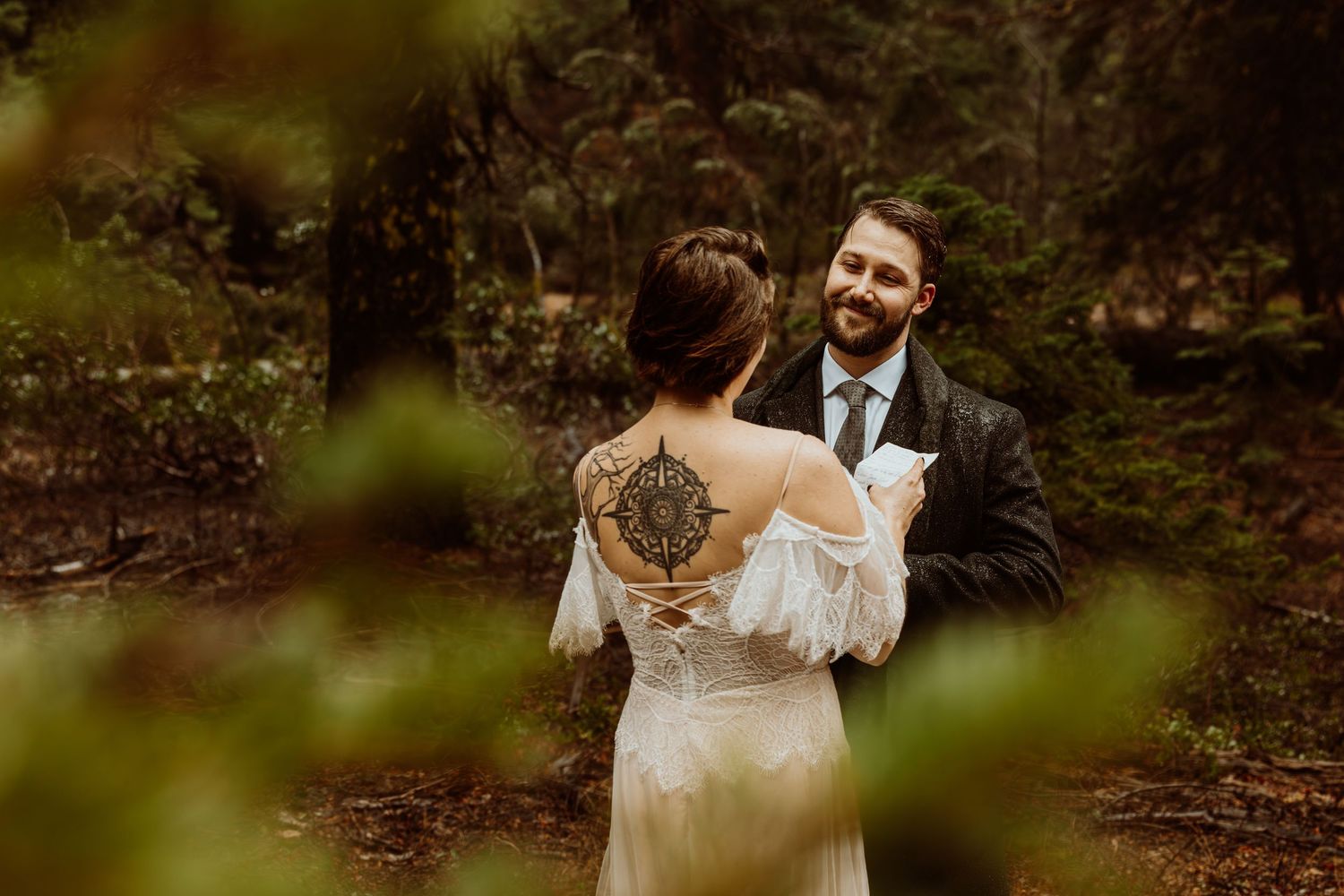 Couple exchanges vows in a lush green forest during an intimate handfasting wedding ceremony.