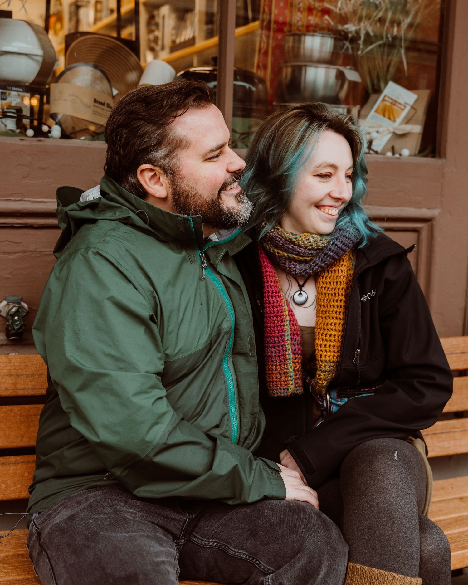 Happy couple sitting together on outdoor steps, smiling and relaxed.