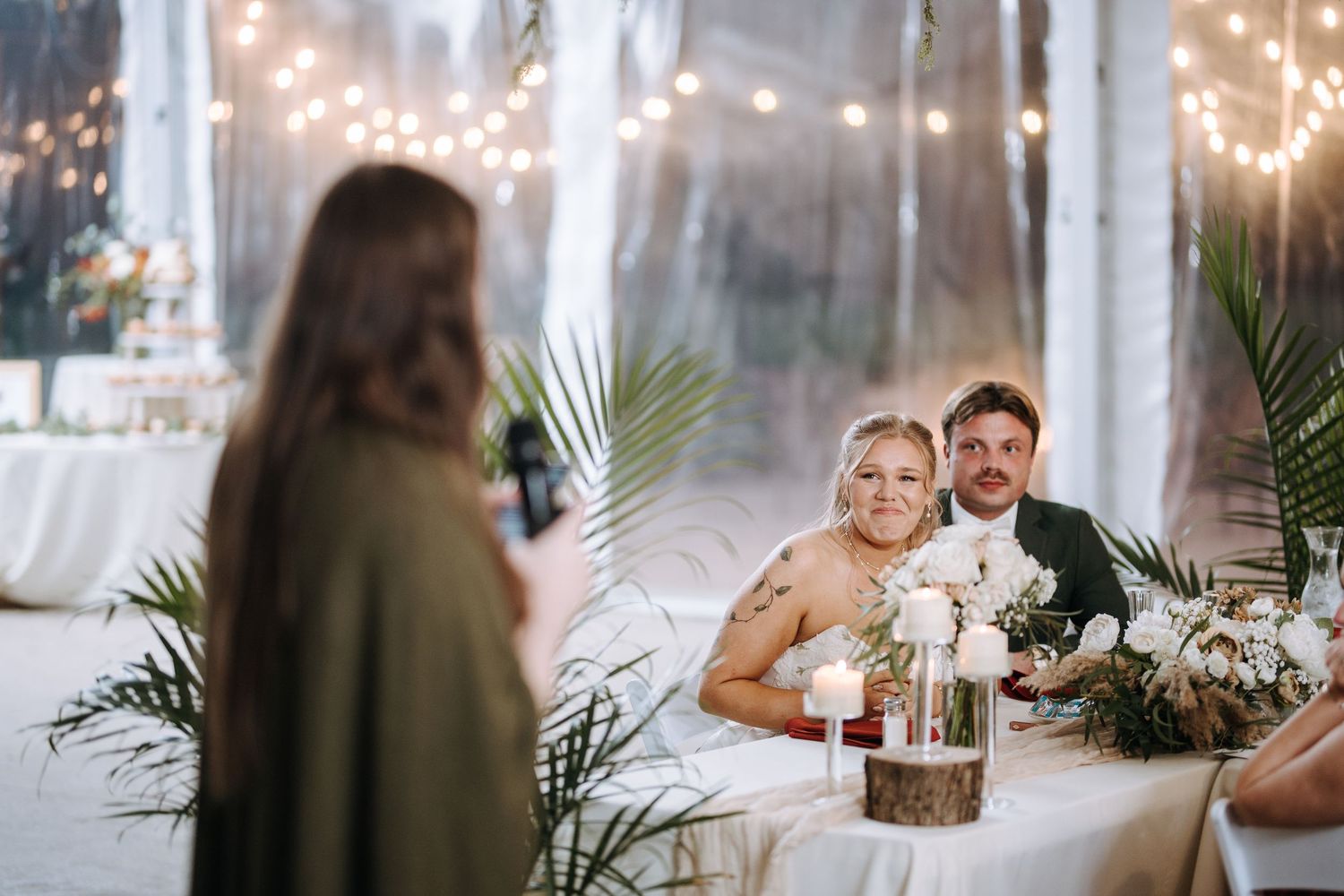 String lights create a romantic ambiance at an indoor wedding reception venue.