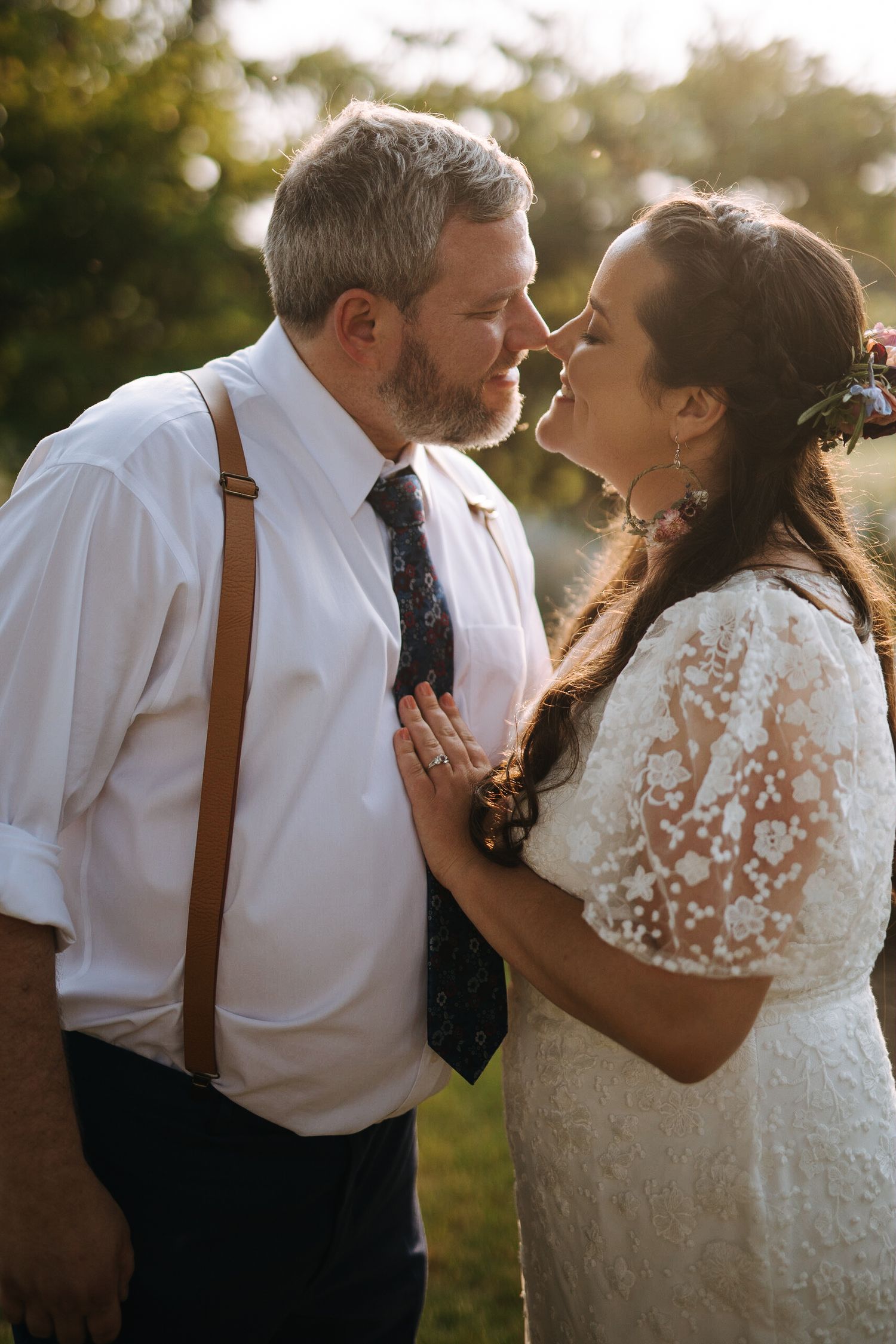 Romantic sunset wedding portraits showing tender moments between a couple in white and brown attire.