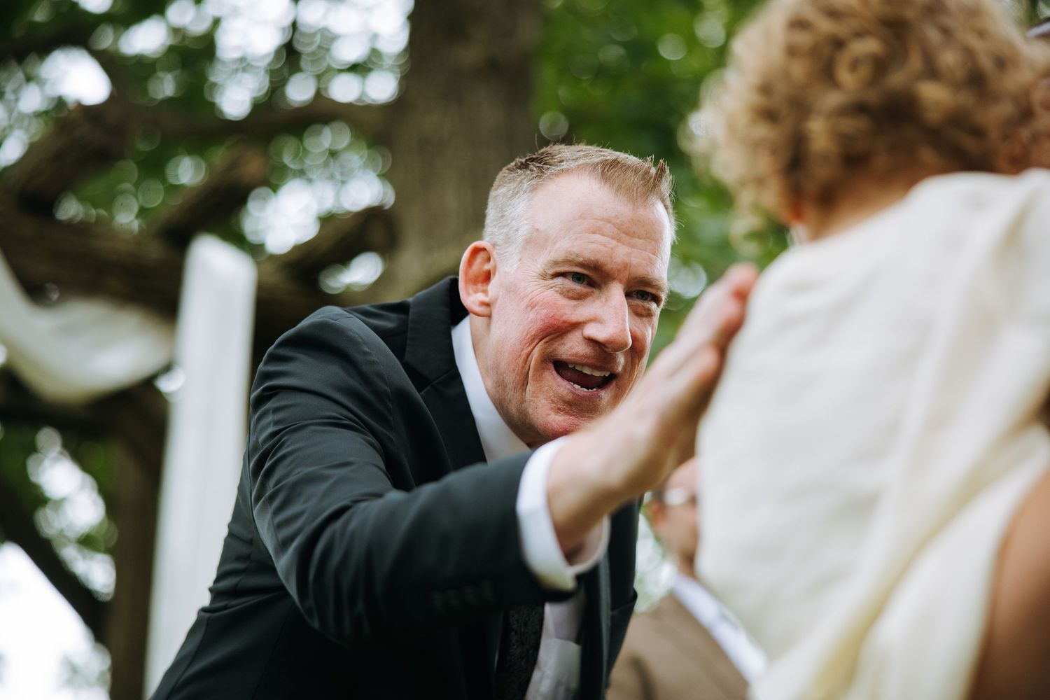Candid emotional moment captured during an outdoor wedding ceremony.