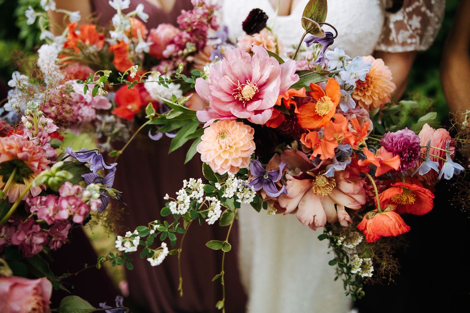 Vibrant floral arrangements featuring pink, orange, and purple blooms with greenery create a romantic wedding atmosphere.