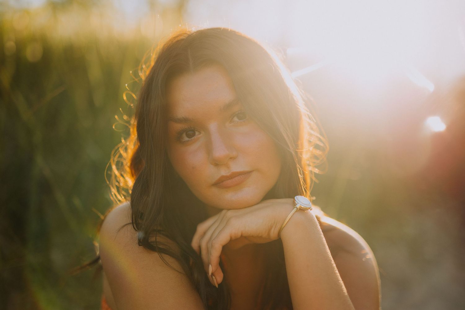 Golden hour portrait session in field with warm sunset lighting.