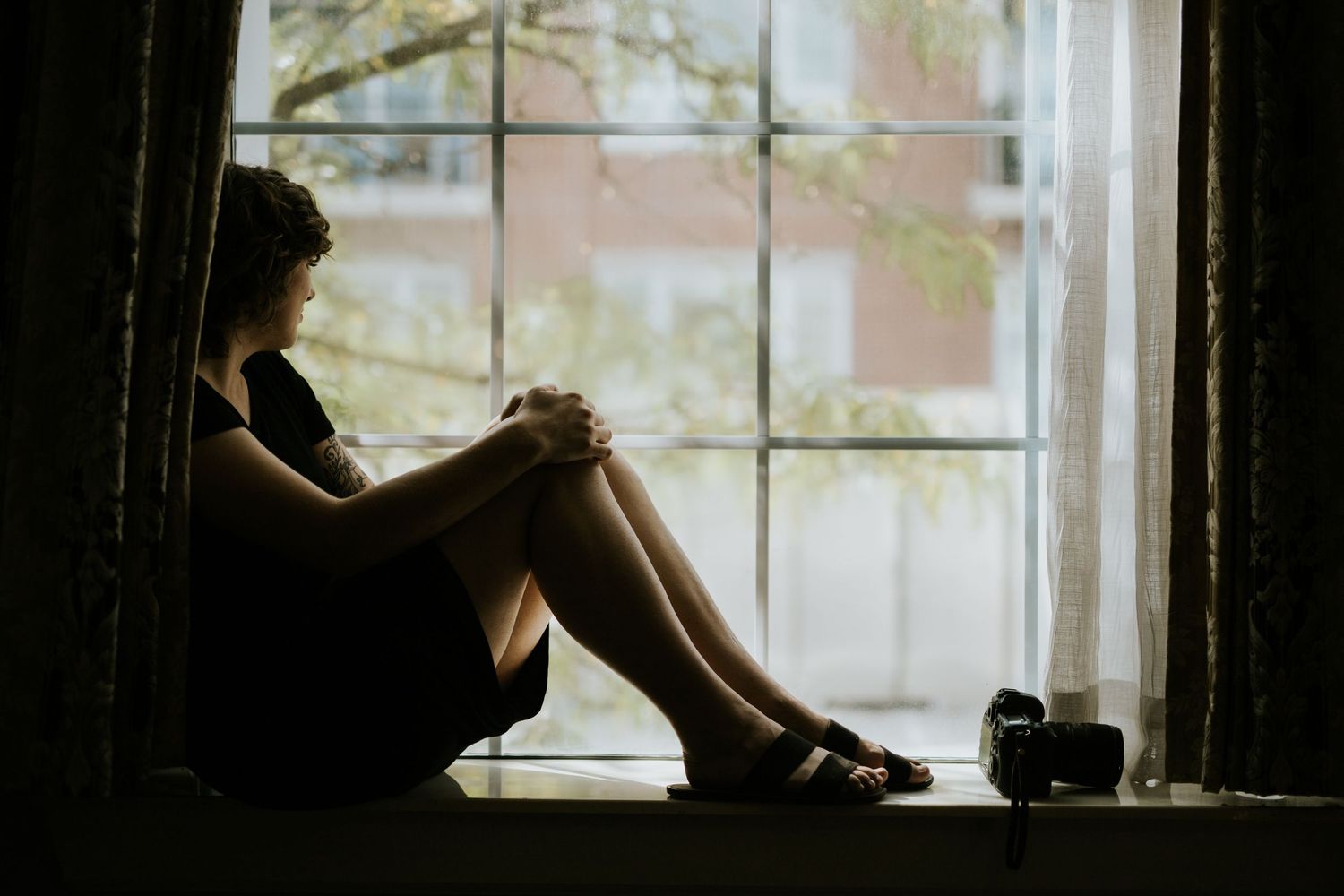Silhouettes of figures against large windows with natural light streaming in.