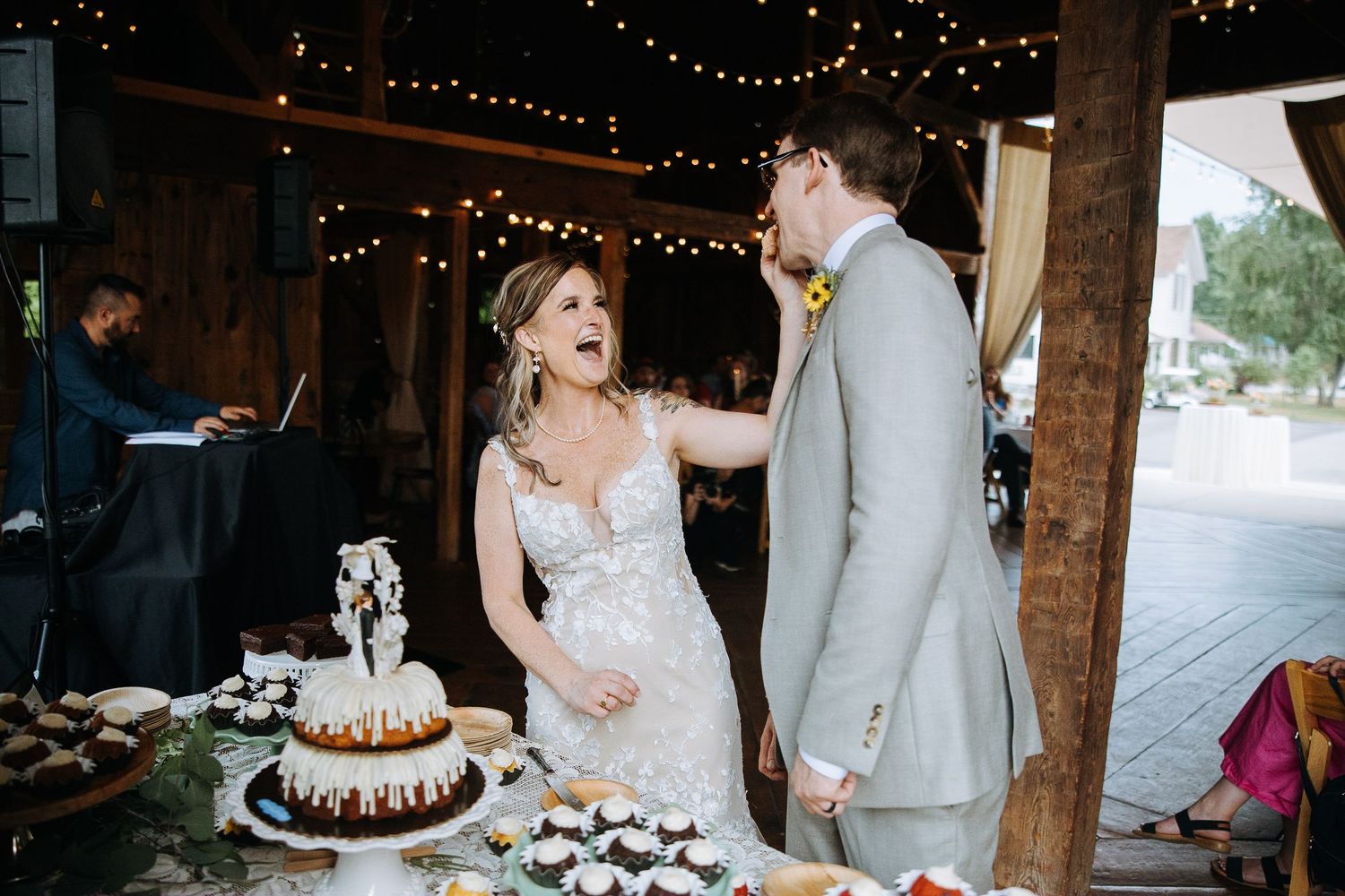 Wedding reception venue with string lights and rustic wooden beams.