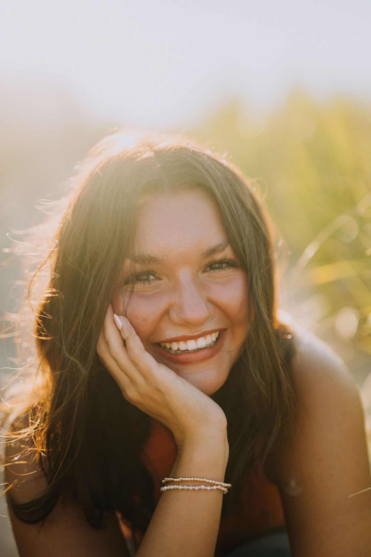 Sunlit portrait with natural backlighting creating a warm, joyful atmosphere.