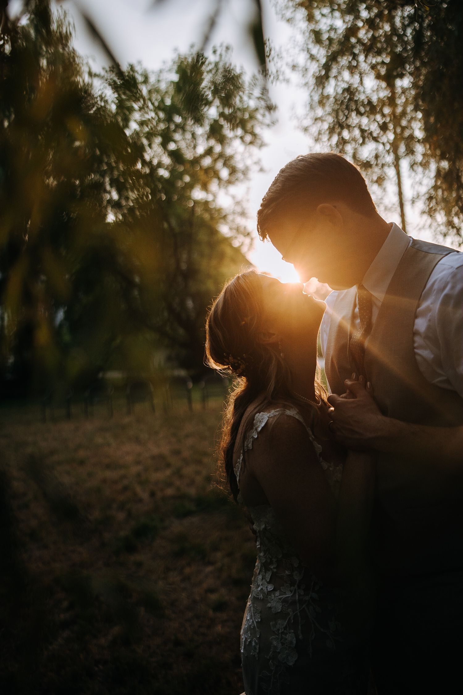 Romantic sunset silhouette of a couple in a natural outdoor setting.