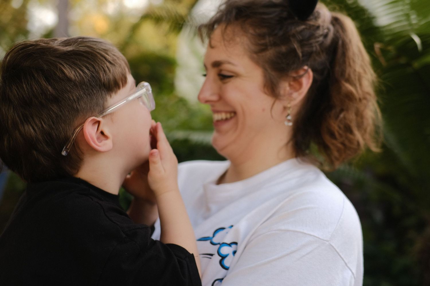 Candid moment of shared laughter and joy captured outdoors in natural lighting.
