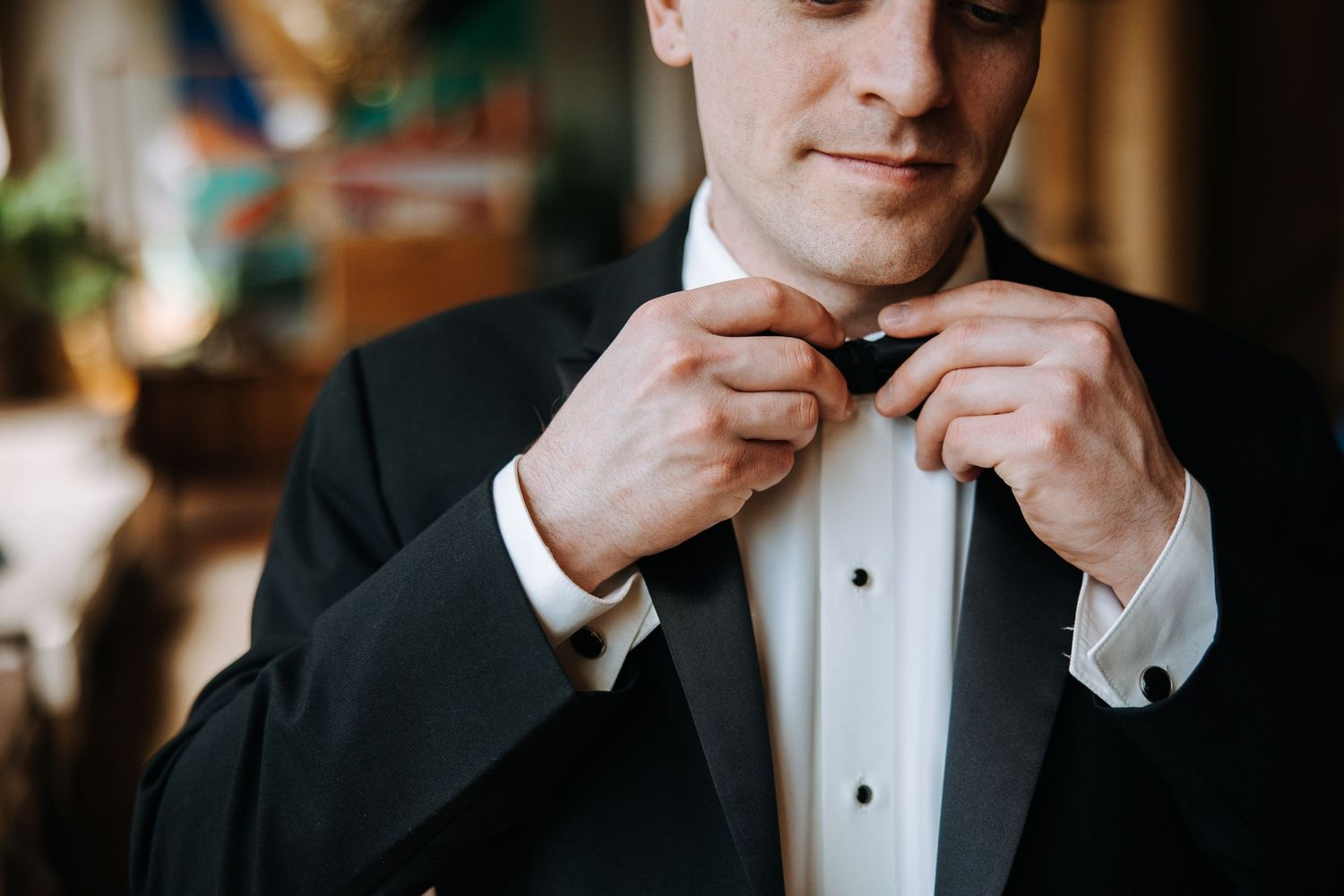 Close-up shot of formal attire as a bowtie is being adjusted.