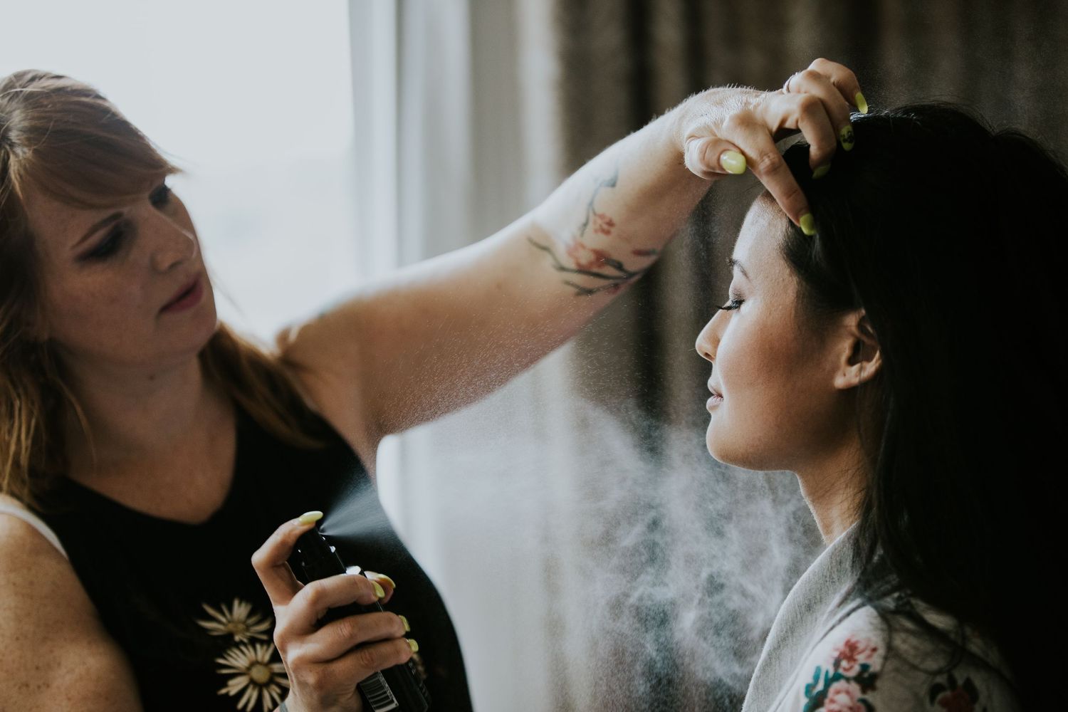 A group of people exhale vapor from e-cigarettes while posing together in dramatic lighting.