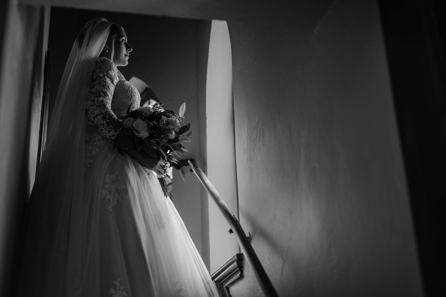 Dramatic black and white wedding portraits captured in elegant interior setting.