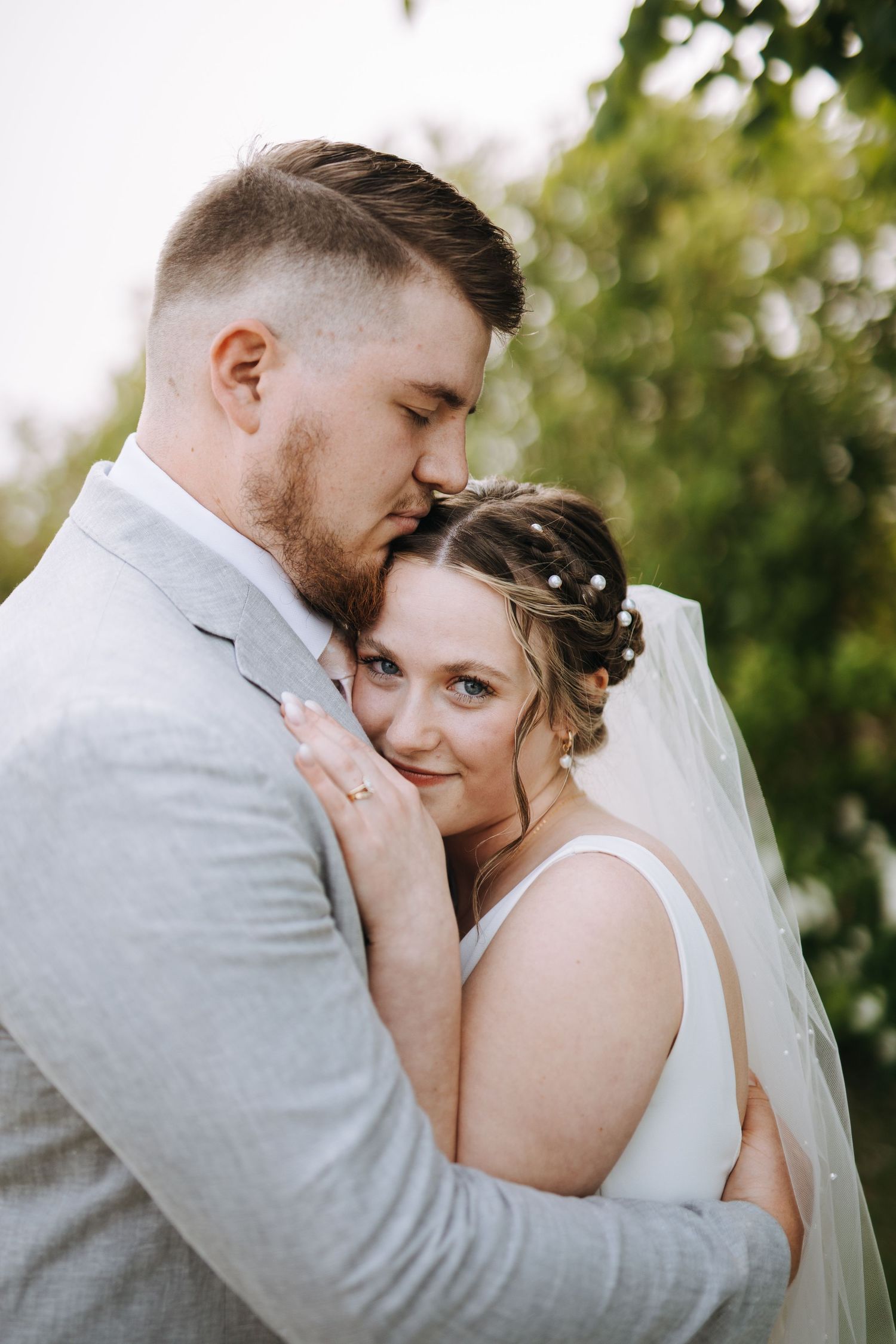 A couple shares an intimate close-up moment during their outdoor wedding photos.