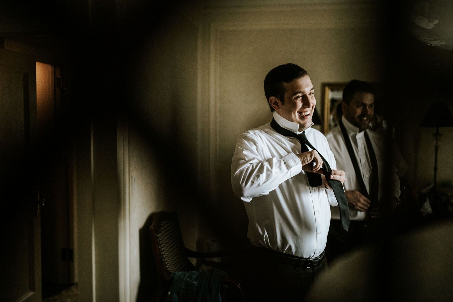 A pre-wedding moment captured in moody lighting as preparations take place.