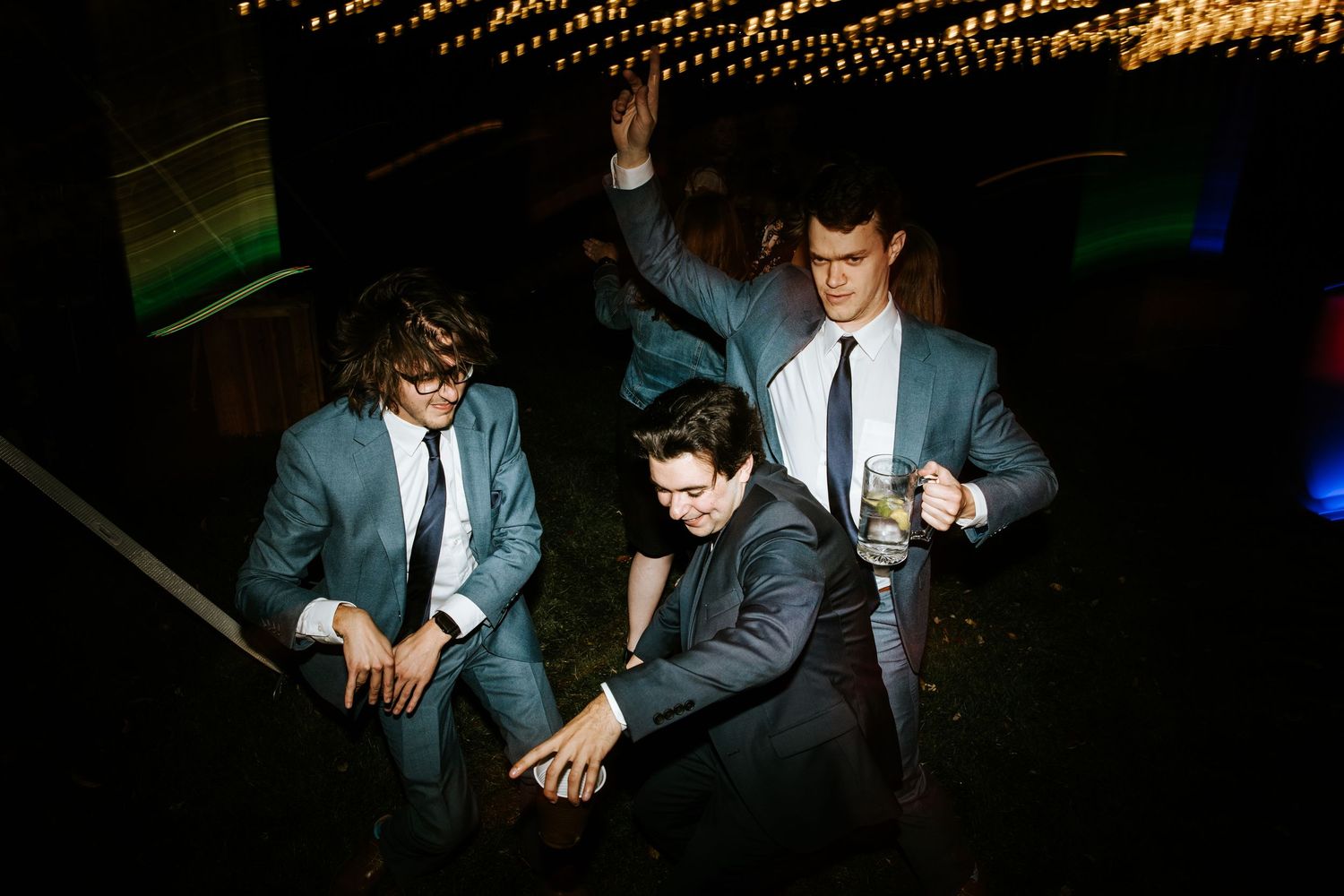 People dancing at a wedding reception with colorful lighting and dynamic movement captured in a photo sequence.