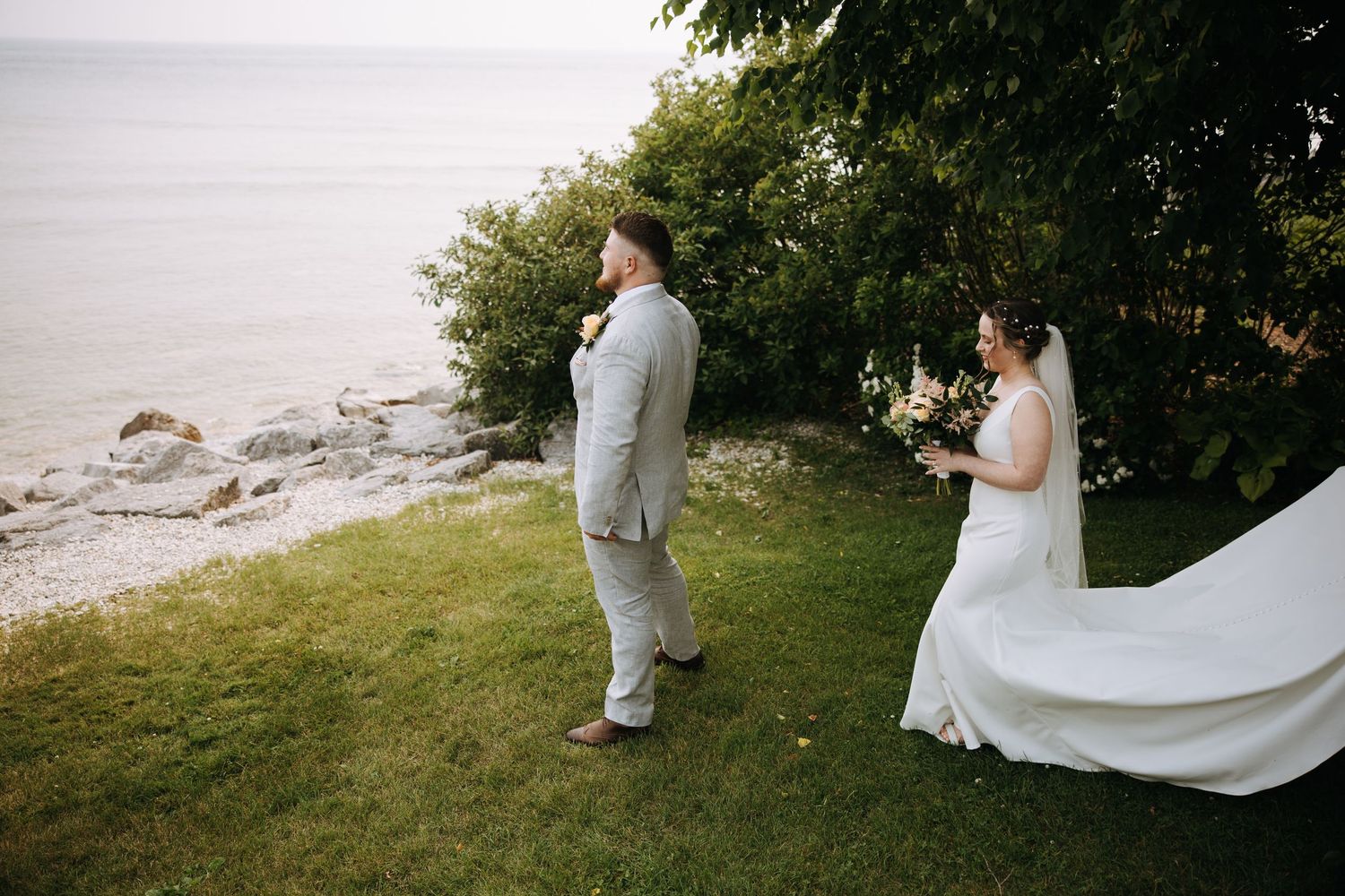 A wedding couple walks together on a scenic coastal path during their photo session.