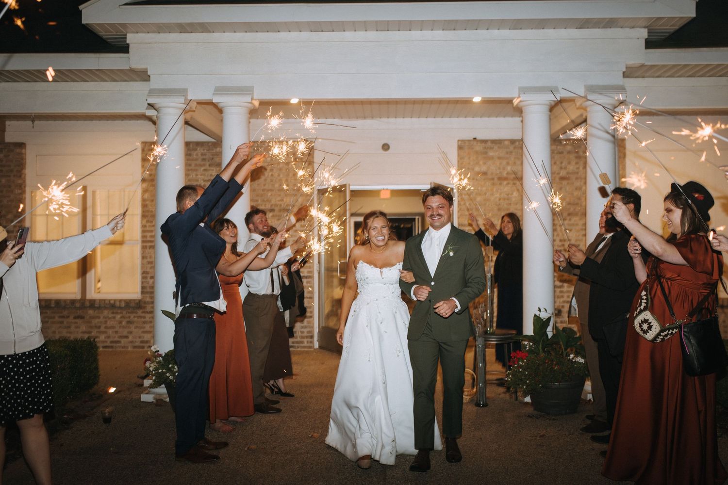 Wide shot of a wedding reception venue with elegant decor and dancing guests.