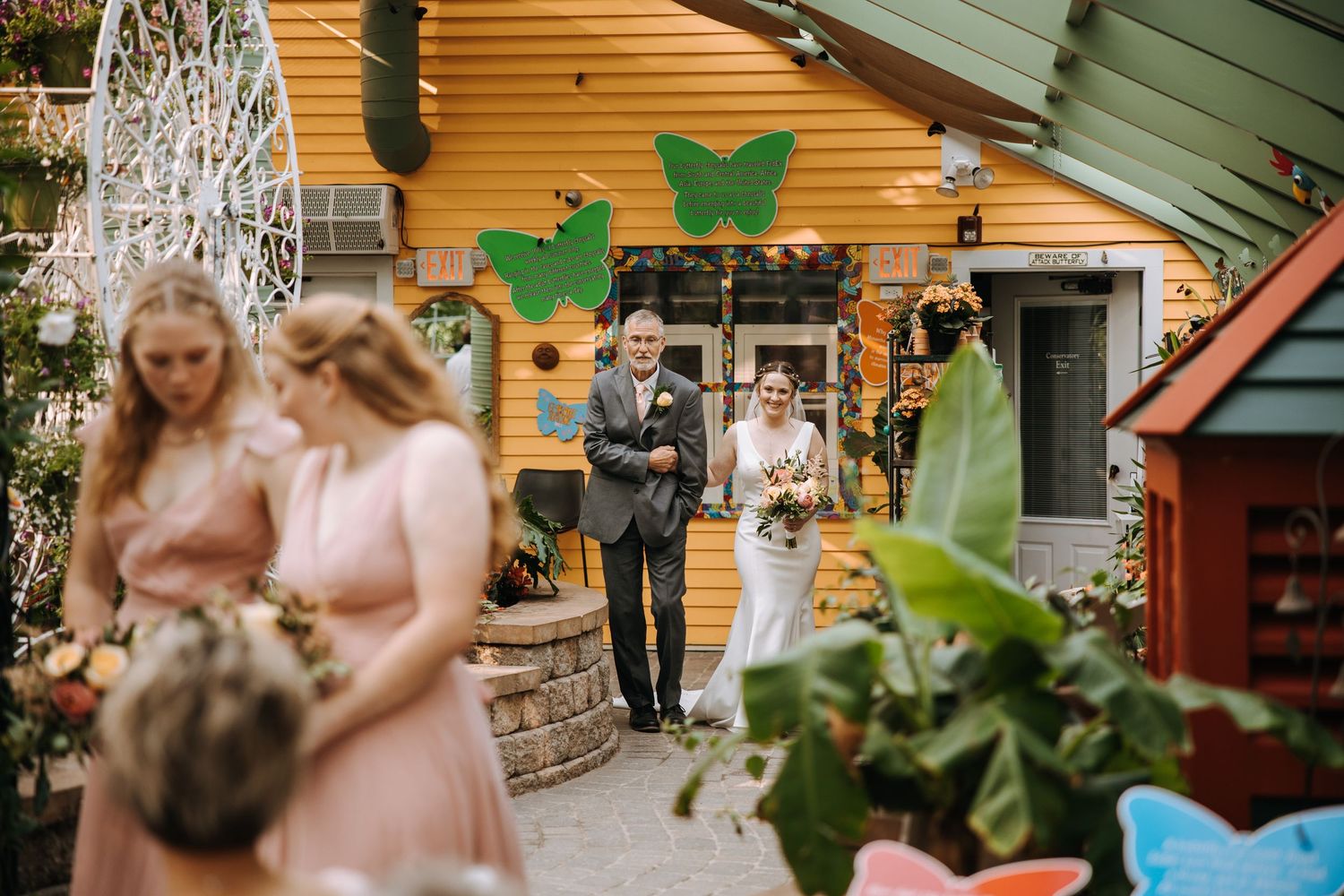 Outdoor wedding venue decorated with yellow walls and green accents.