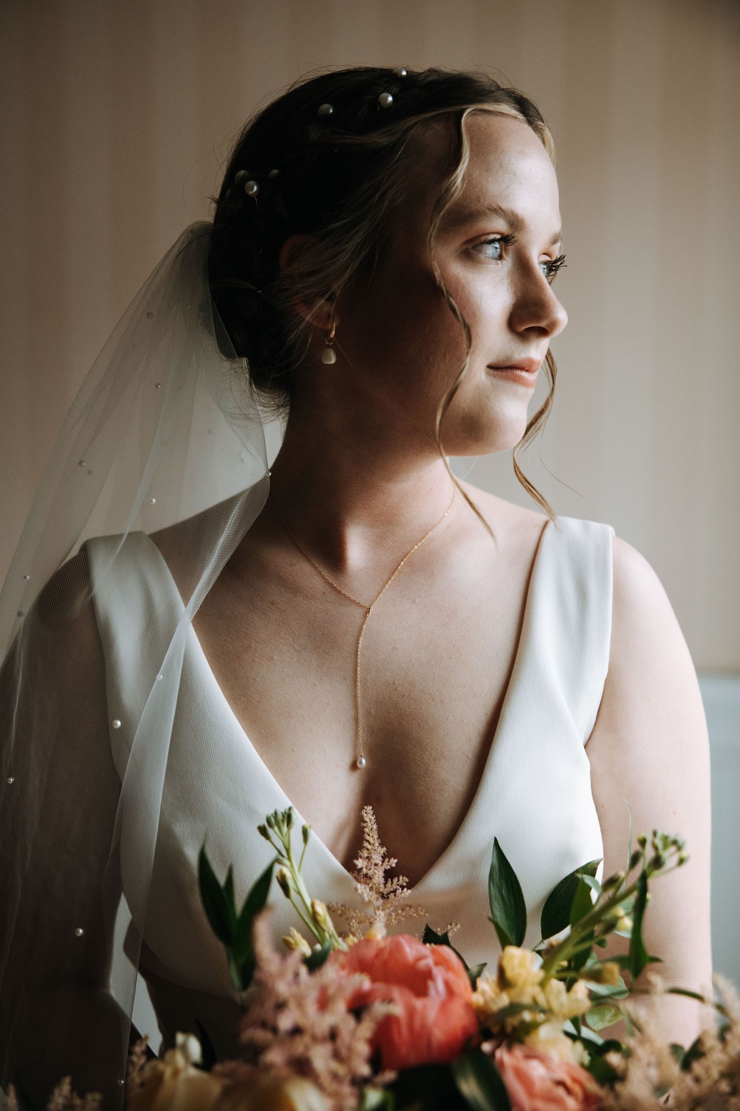 Artistic bridal portrait with soft lighting and colorful floral bouquet.