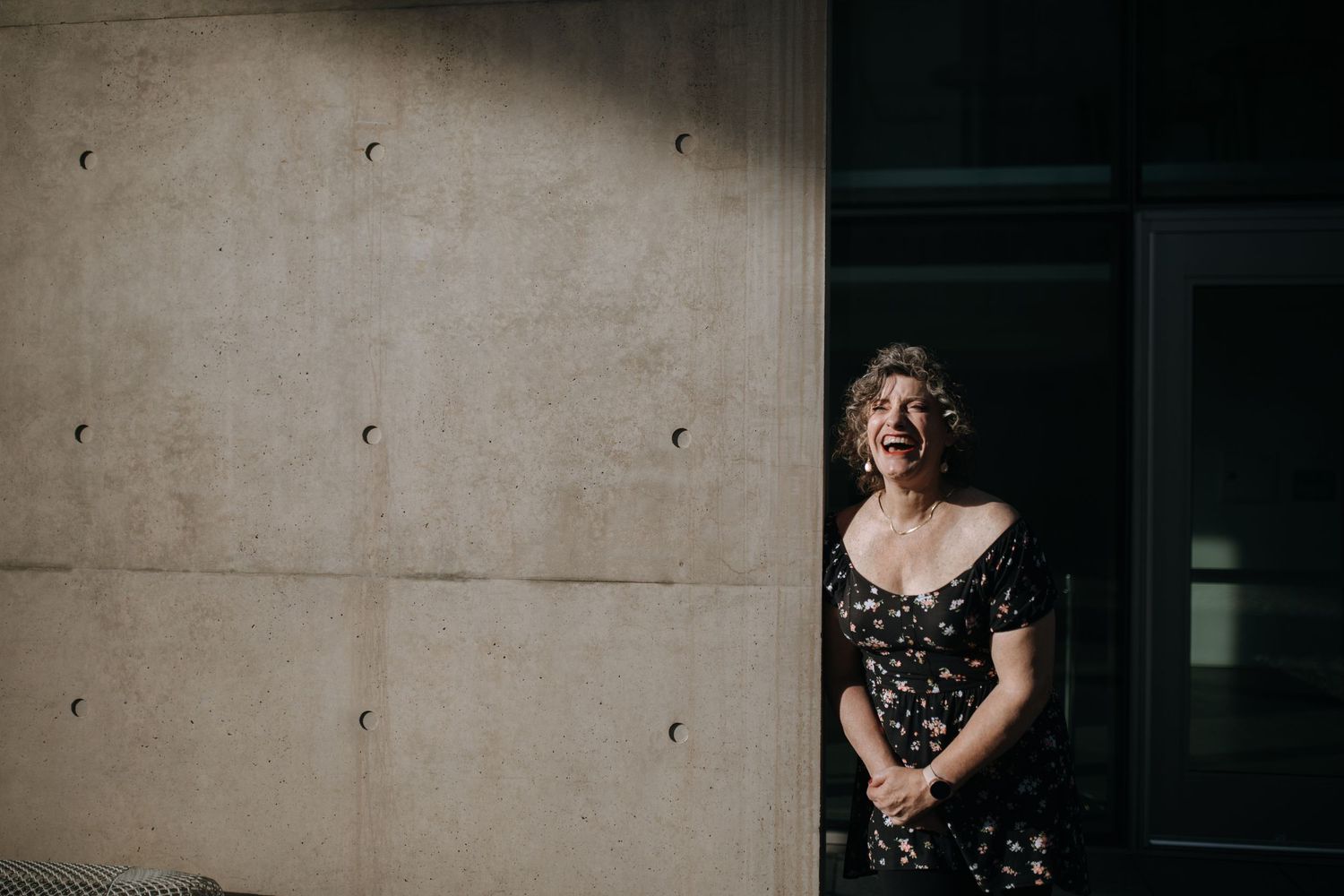 Natural candid portraits against an industrial concrete wall background.