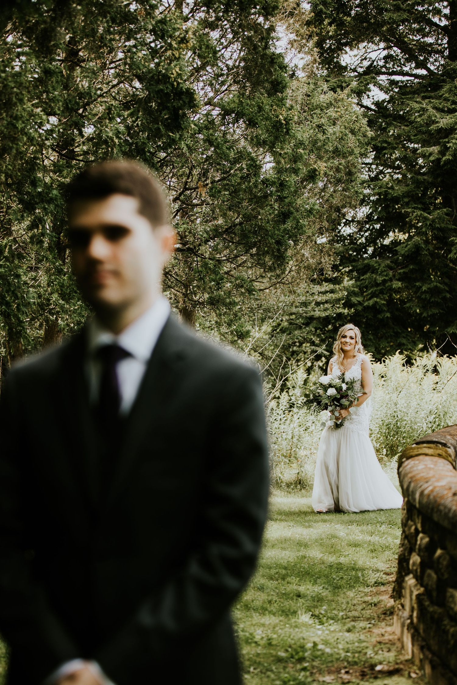 Outdoor wedding ceremony setup in a garden with trees creating natural shade.