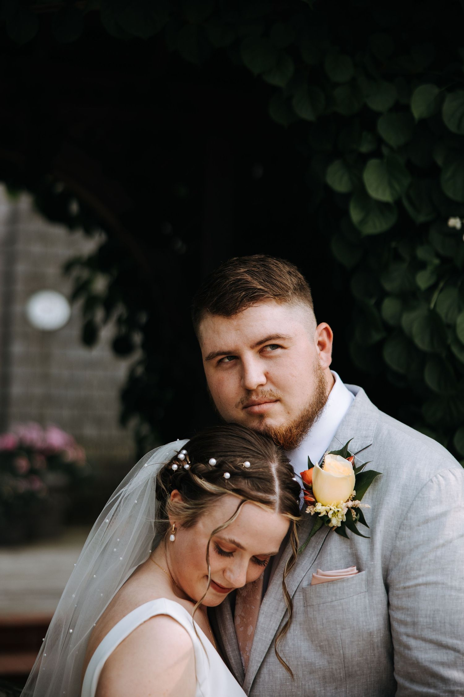 An intimate wedding portrait taken under natural greenery and shadows.