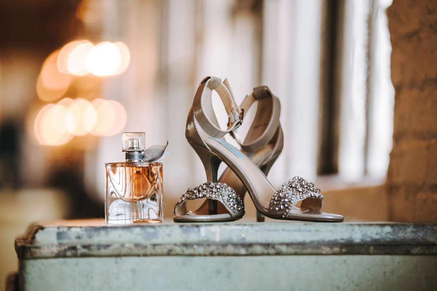 A romantic wedding table setting with elegant glassware, candles and floral arrangements in warm ambient lighting.