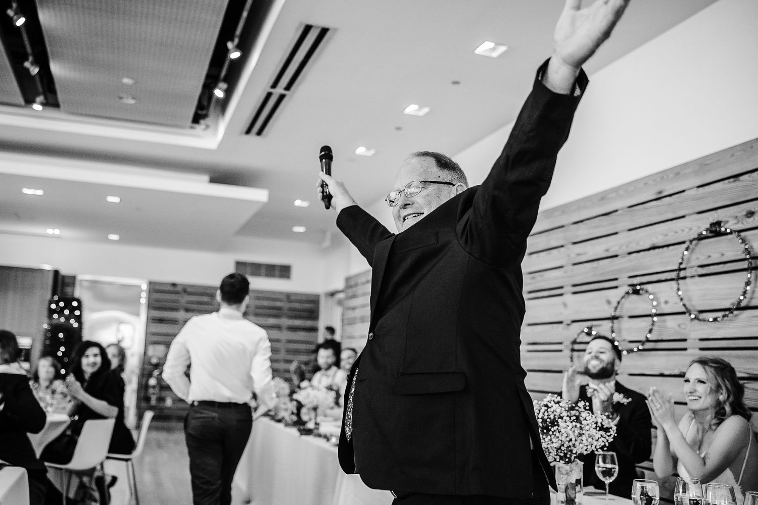 Wedding party celebrates with energetic dance moves in modern venue.