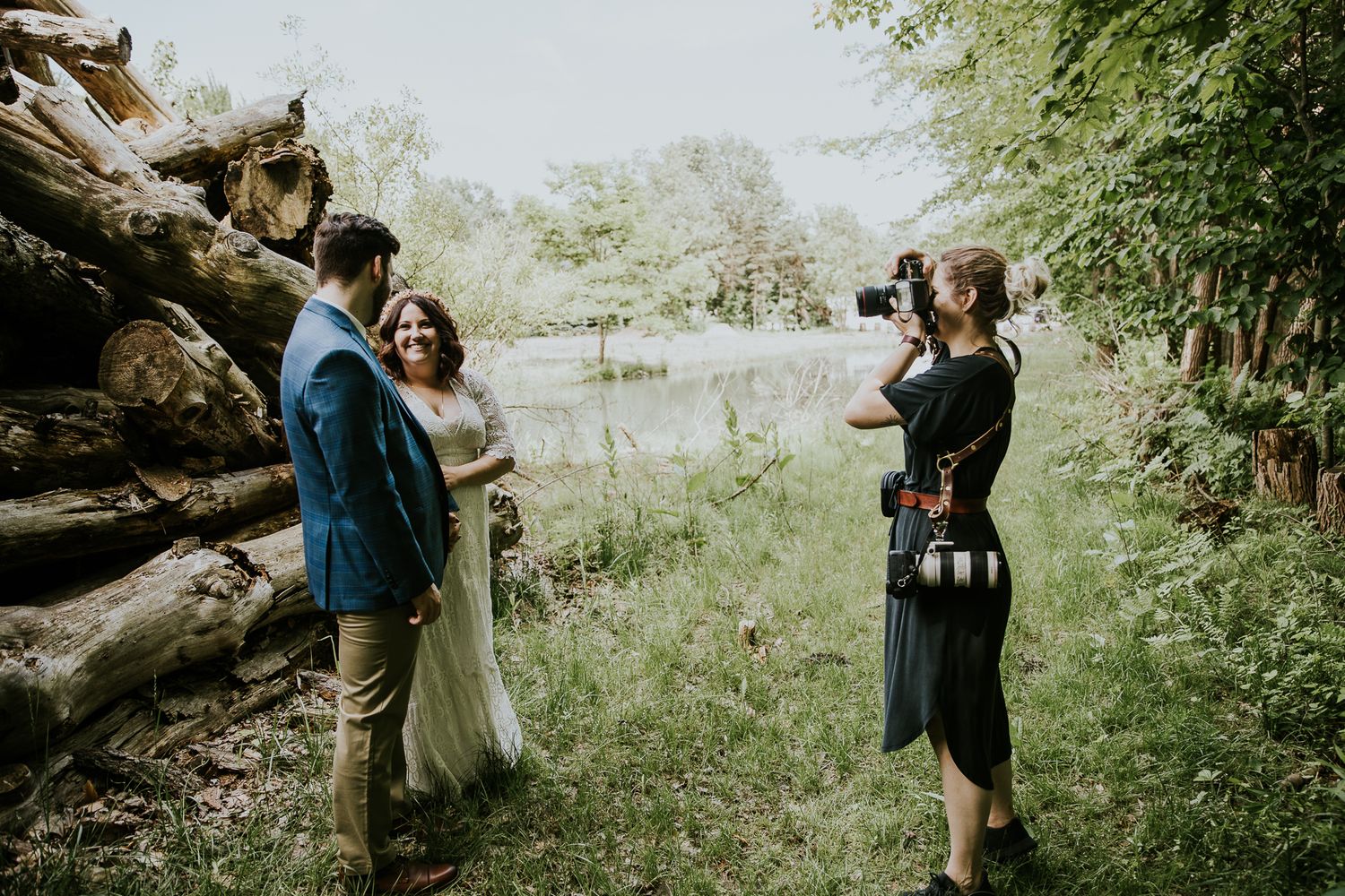 A couple shares a romantic moment in a lush outdoor setting with natural greenery.