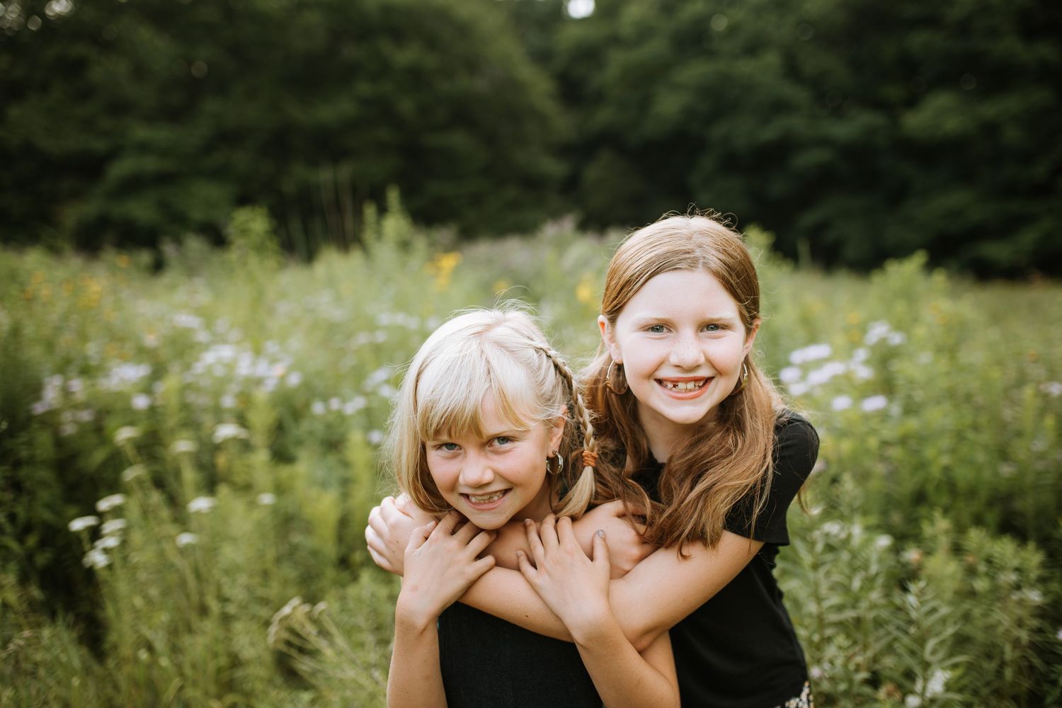 Family members embrace while enjoying time together in an outdoor field setting.