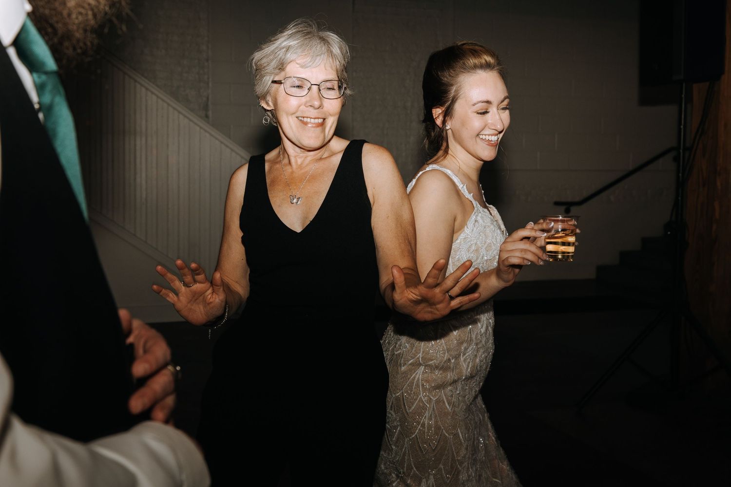 Wedding guests dancing and celebrating at reception.