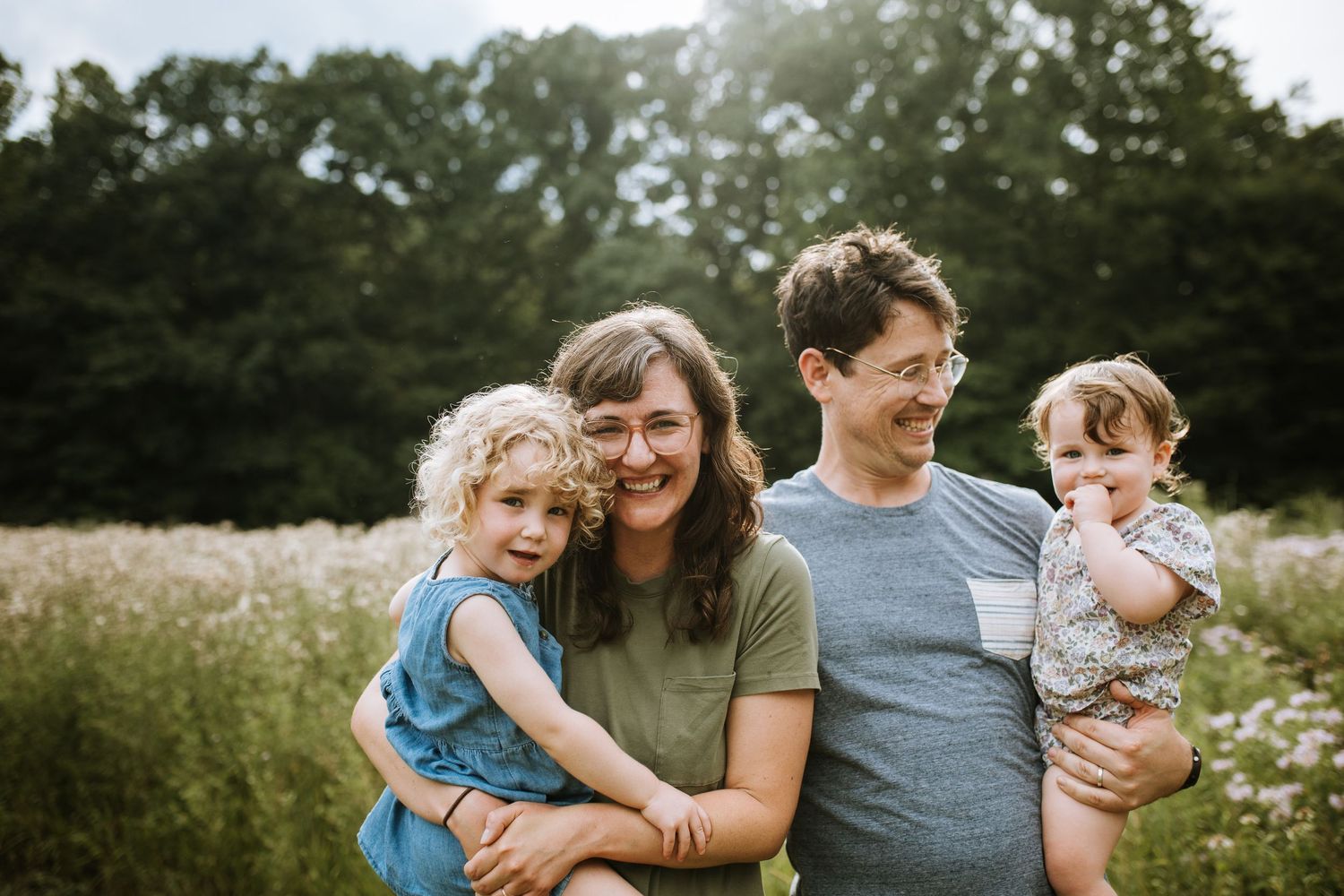 Parents and children share tender moments together in a summer field.