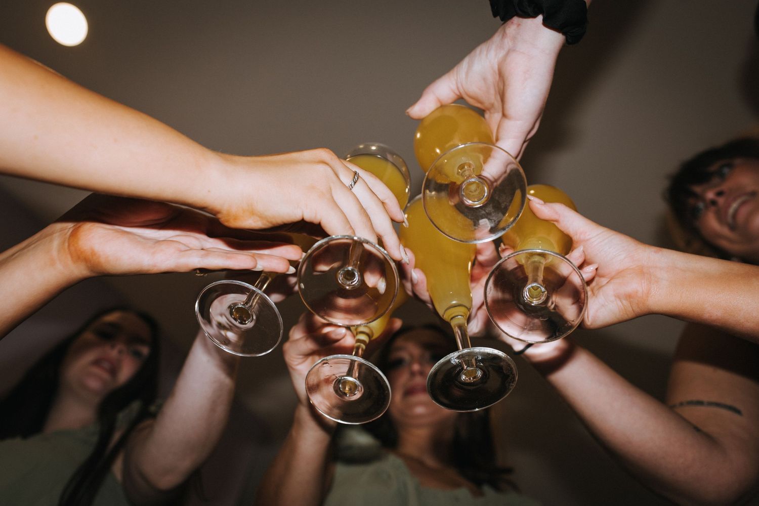 Wedding guests raise champagne glasses in a celebratory toast during reception.