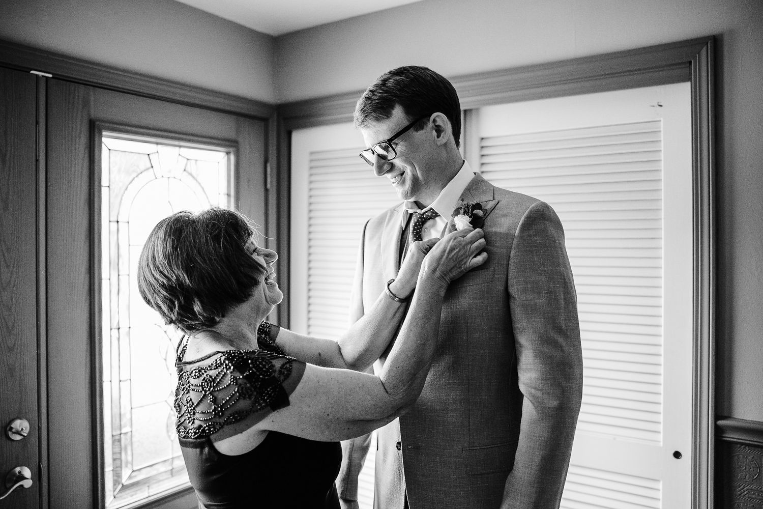 Emotional wedding preparation moment in bright indoor setting.