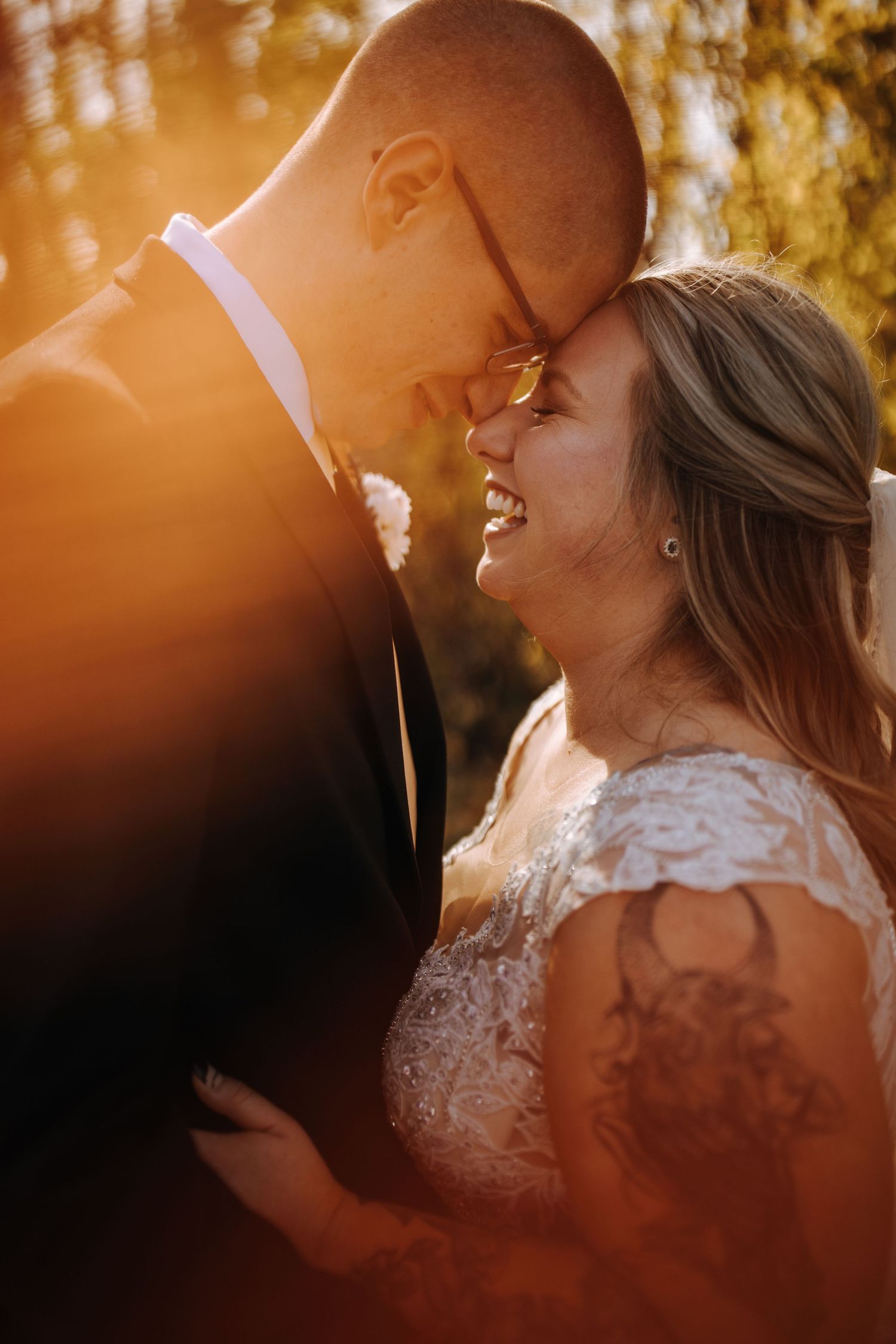 Golden sunset light creates romantic glow during outdoor wedding portraits.