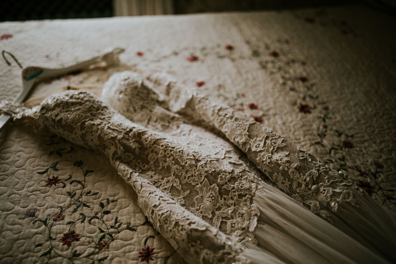 Close-up detail shot of intricate lace pattern on a wedding dress.