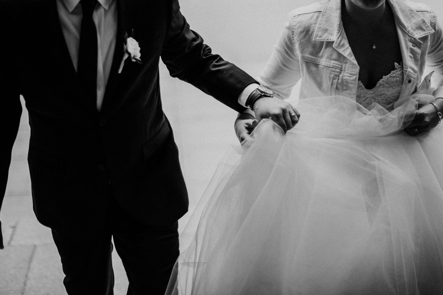 Black and white photo showing formal wedding attire details.