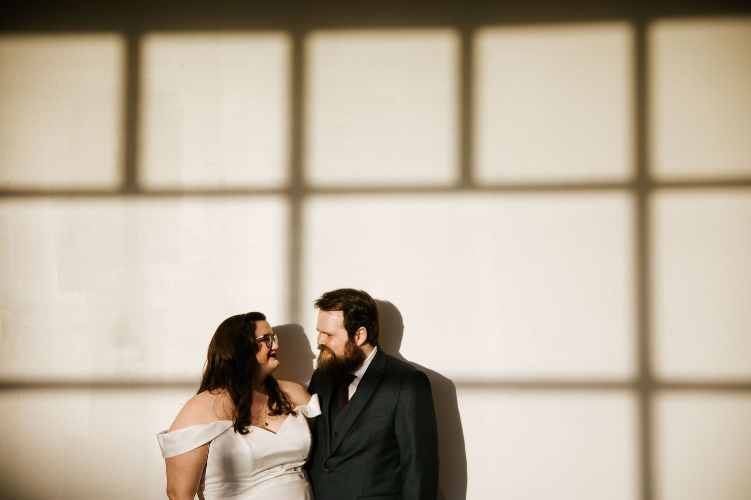 Silhouetted figures in a minimalist hallway create dramatic wedding portraits.