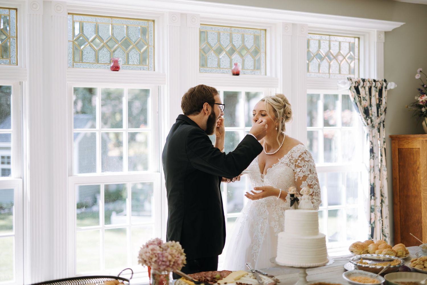 Elegant white-trimmed wedding venue with large windows and natural lighting.