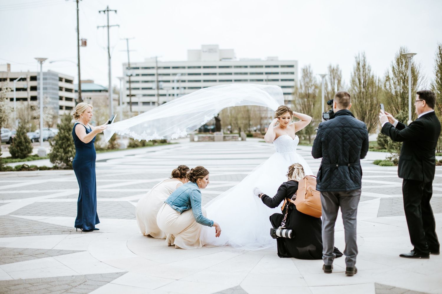 Wedding celebration taking place in an urban setting with modern buildings in background.