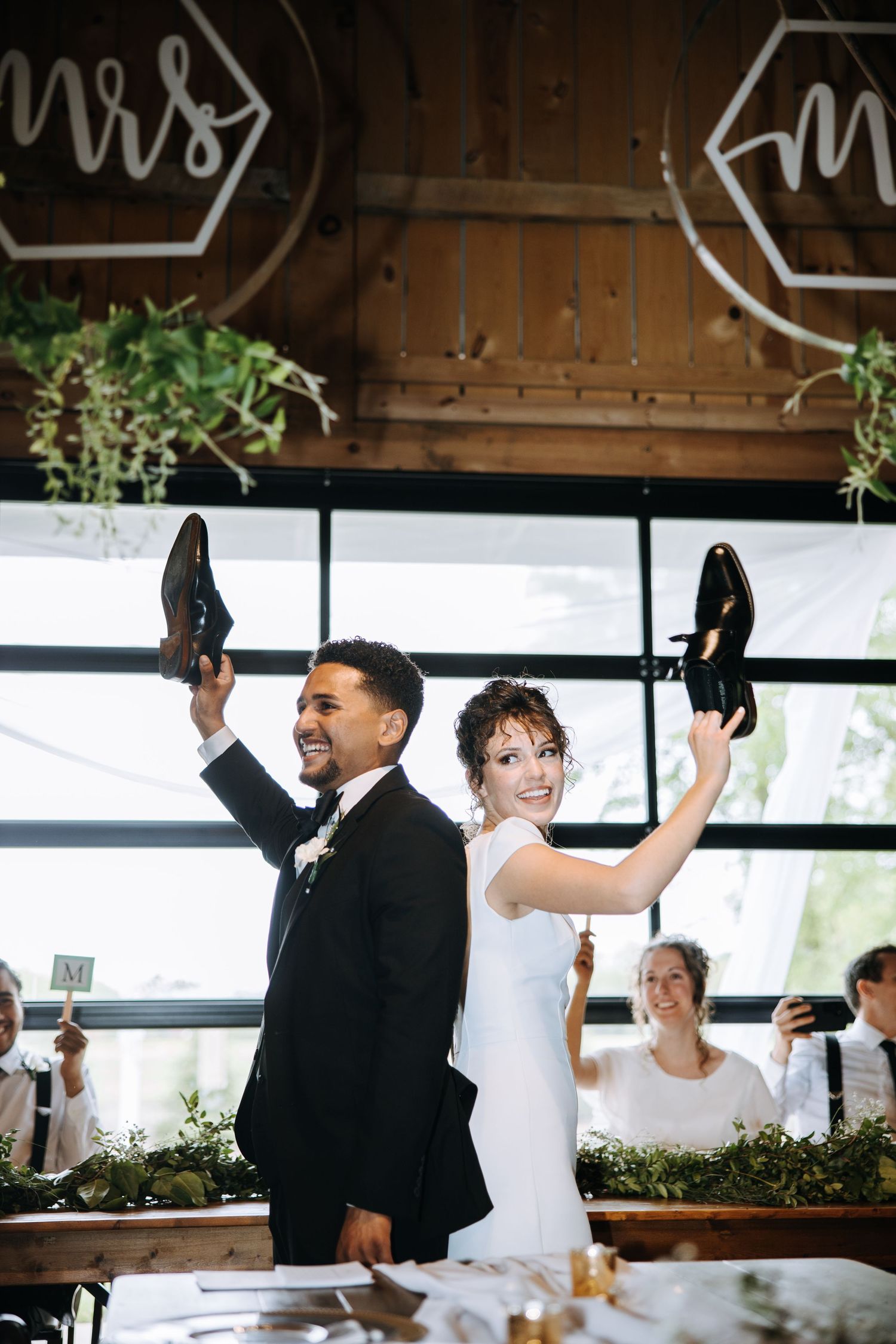 Wedding celebration with dancing and festivities inside a modern rustic venue.